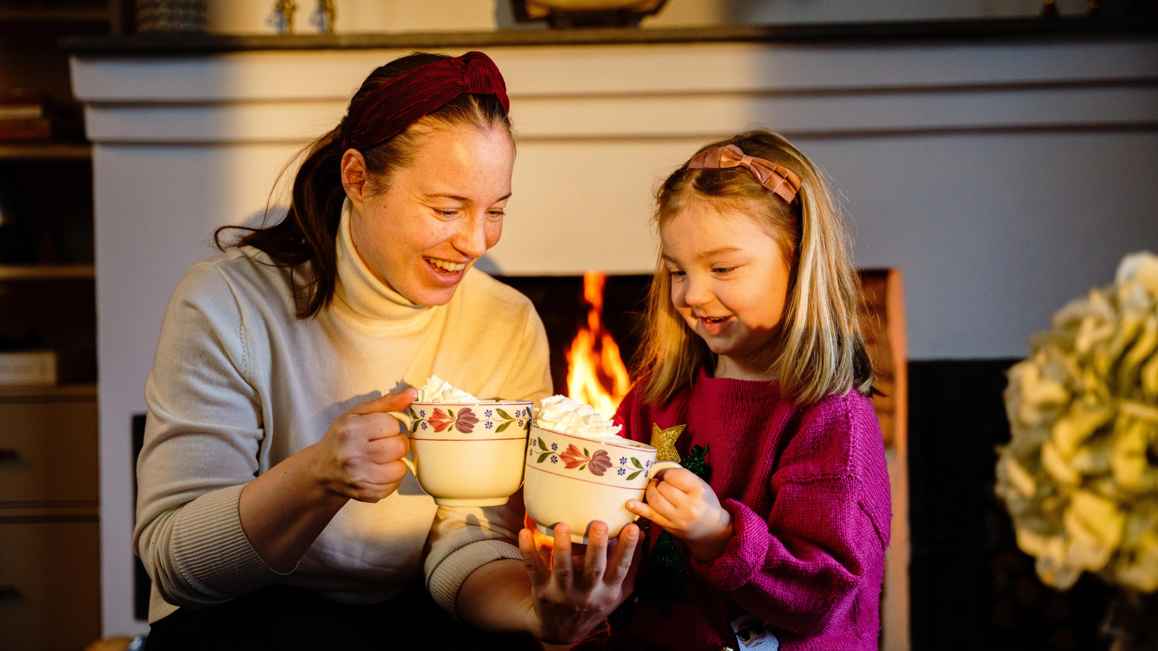 A mother and her daughter enjoying some hot chocolate