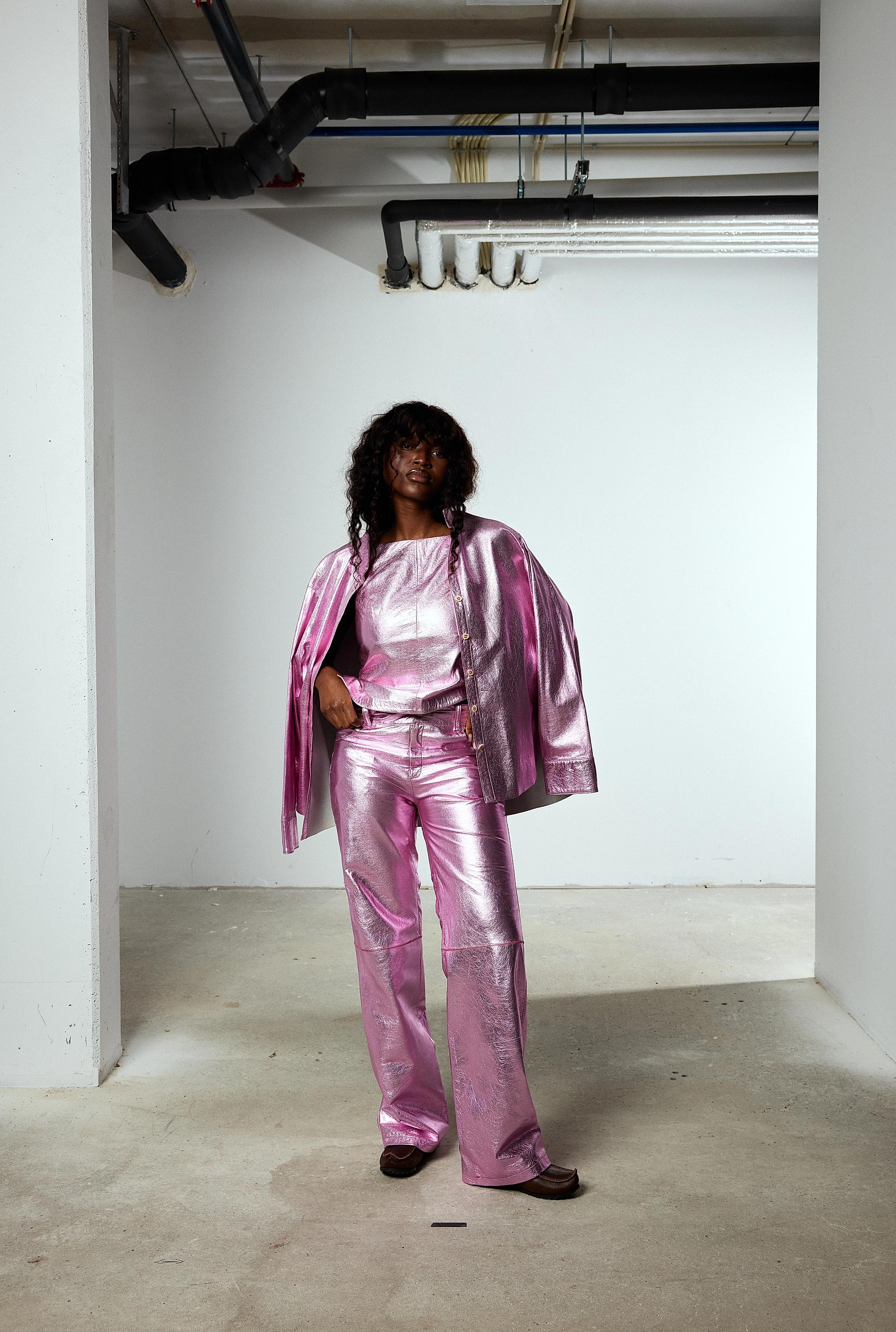 Woman in a shiny pink reindeer leather set from the brand Gobmi