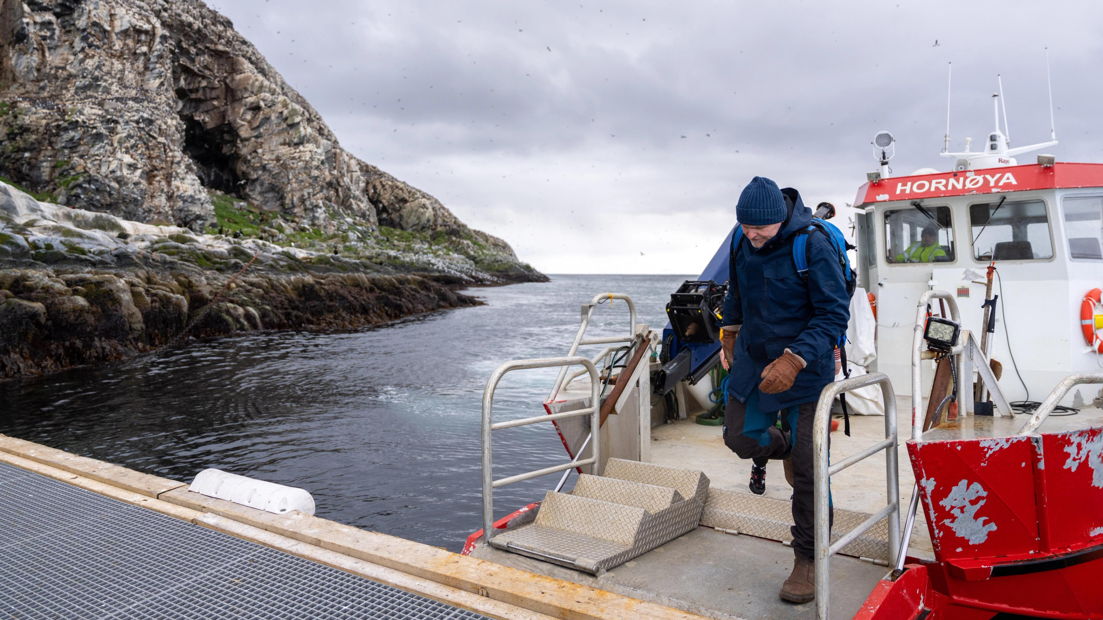 A man have taken a boat to go to Hornøya island outside of Vardø in Varanger, Northern Norway
