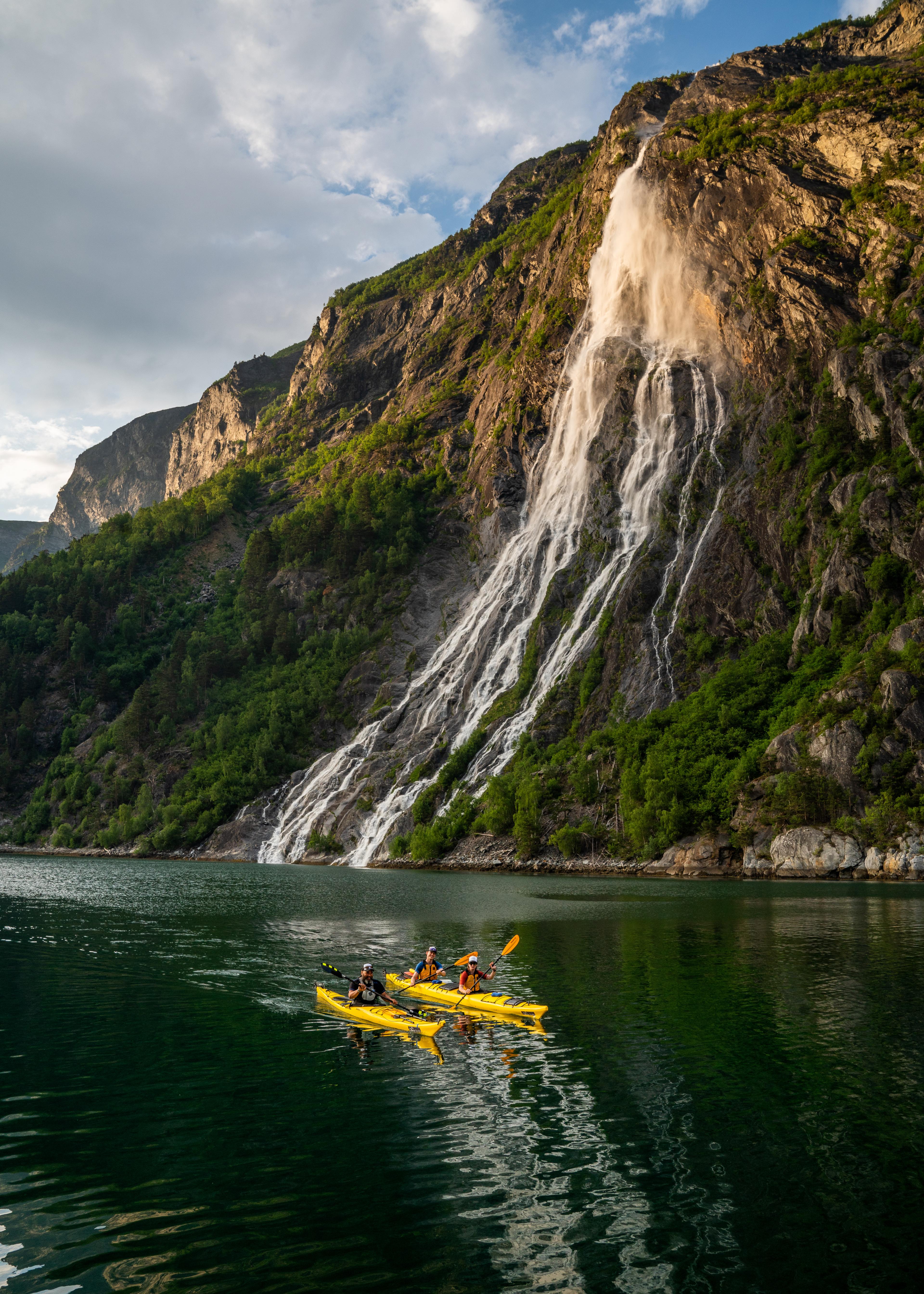 A group of people are kayaking in Tafjord in Valldal, Fjord Norway