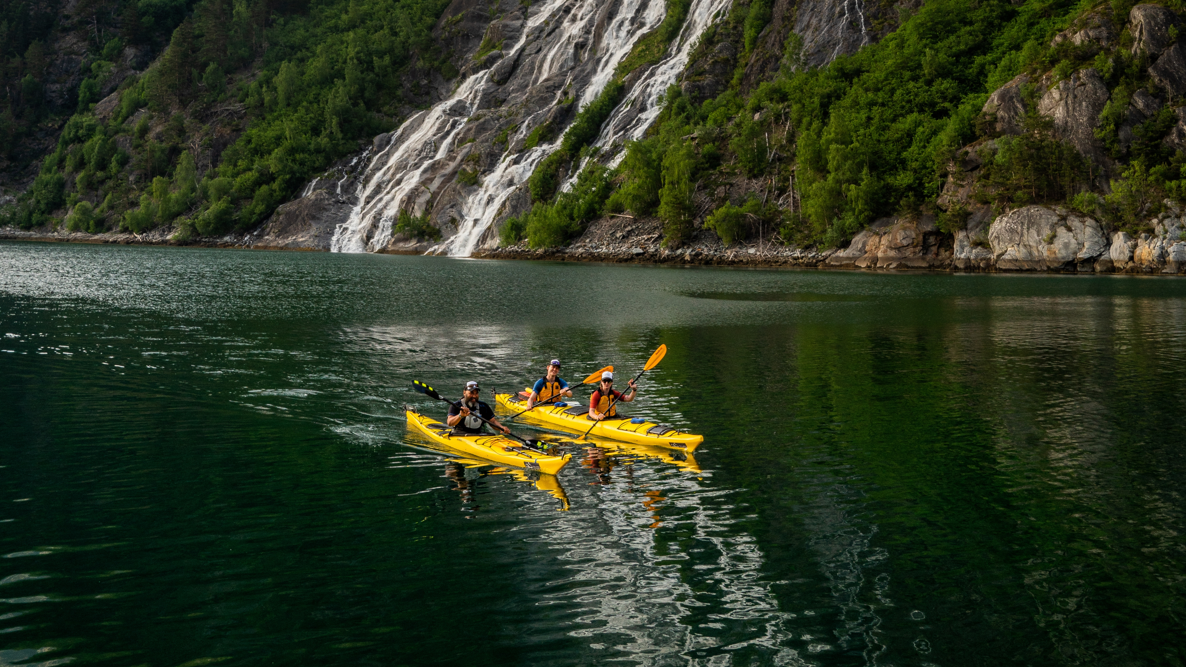 A group of people are kayaking in Tafjord in Valldal, Fjord Norway