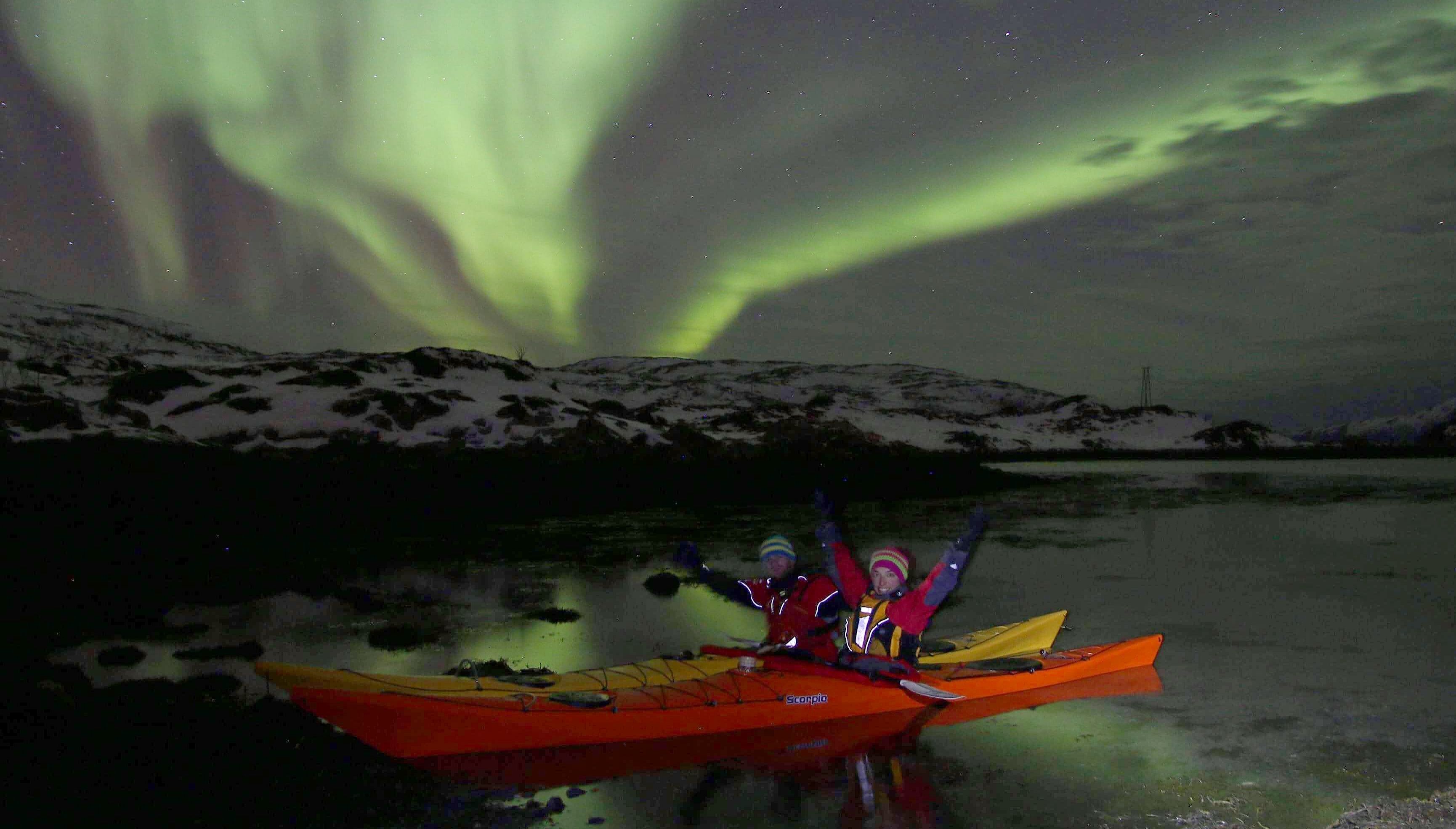 Anita Andresen on a kayak below the Northern Lights close to Tromsø in Northern Norway