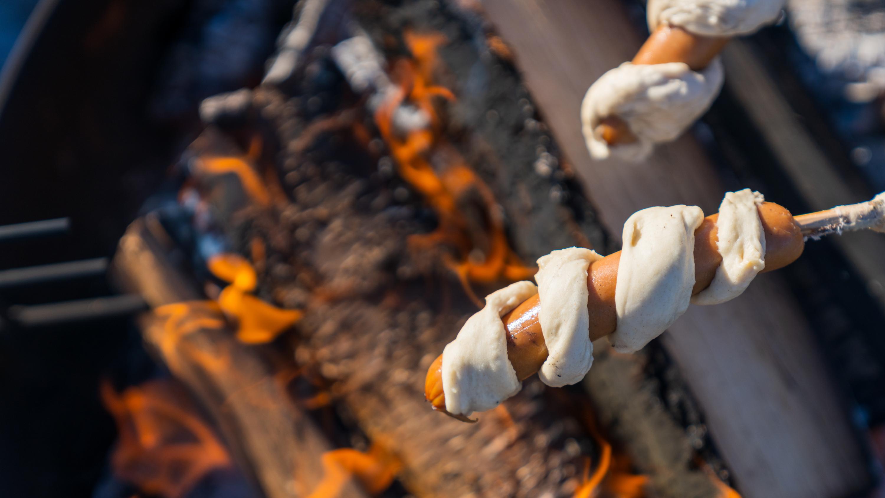 Pinnebrød being grilled at the campfire in the woods, Grefsenkollen, Norway