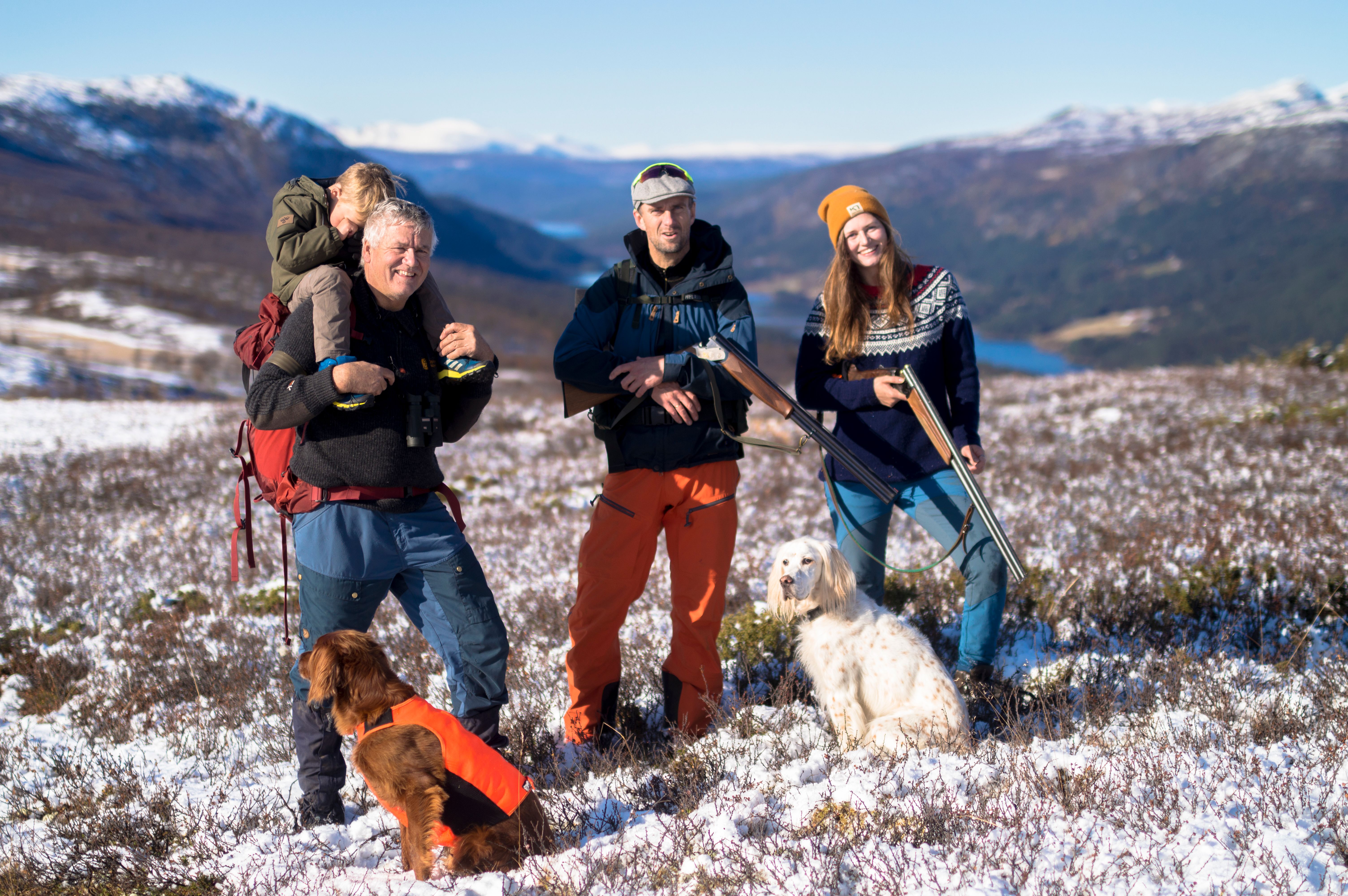 Mor, far og sønn sitter i lyngen og tar seg en pause fra jakten en høstdag i den norske fjellheimen