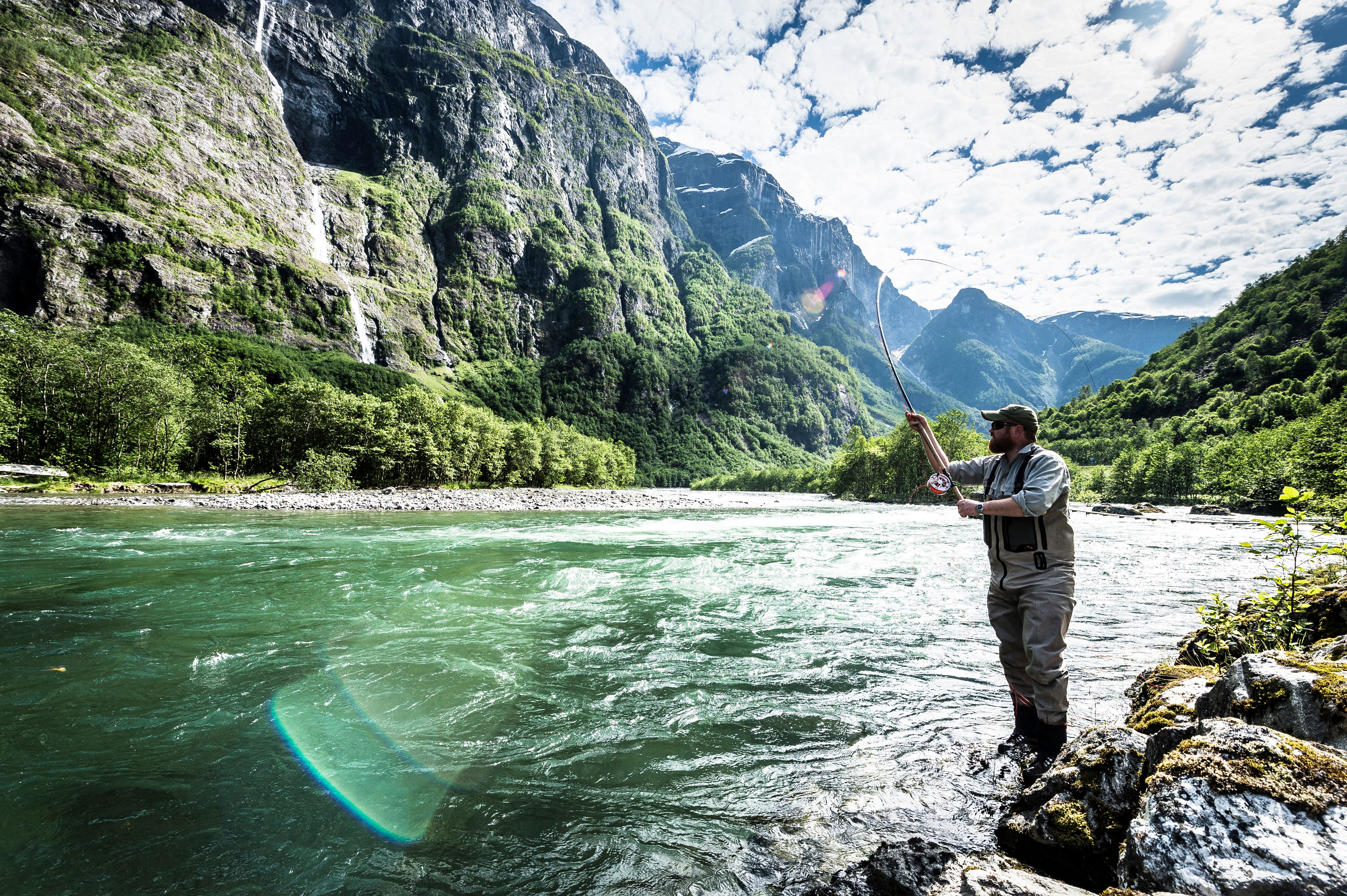 A man fishing for wild salmon in the Nærøydalselva in Fjord Norway