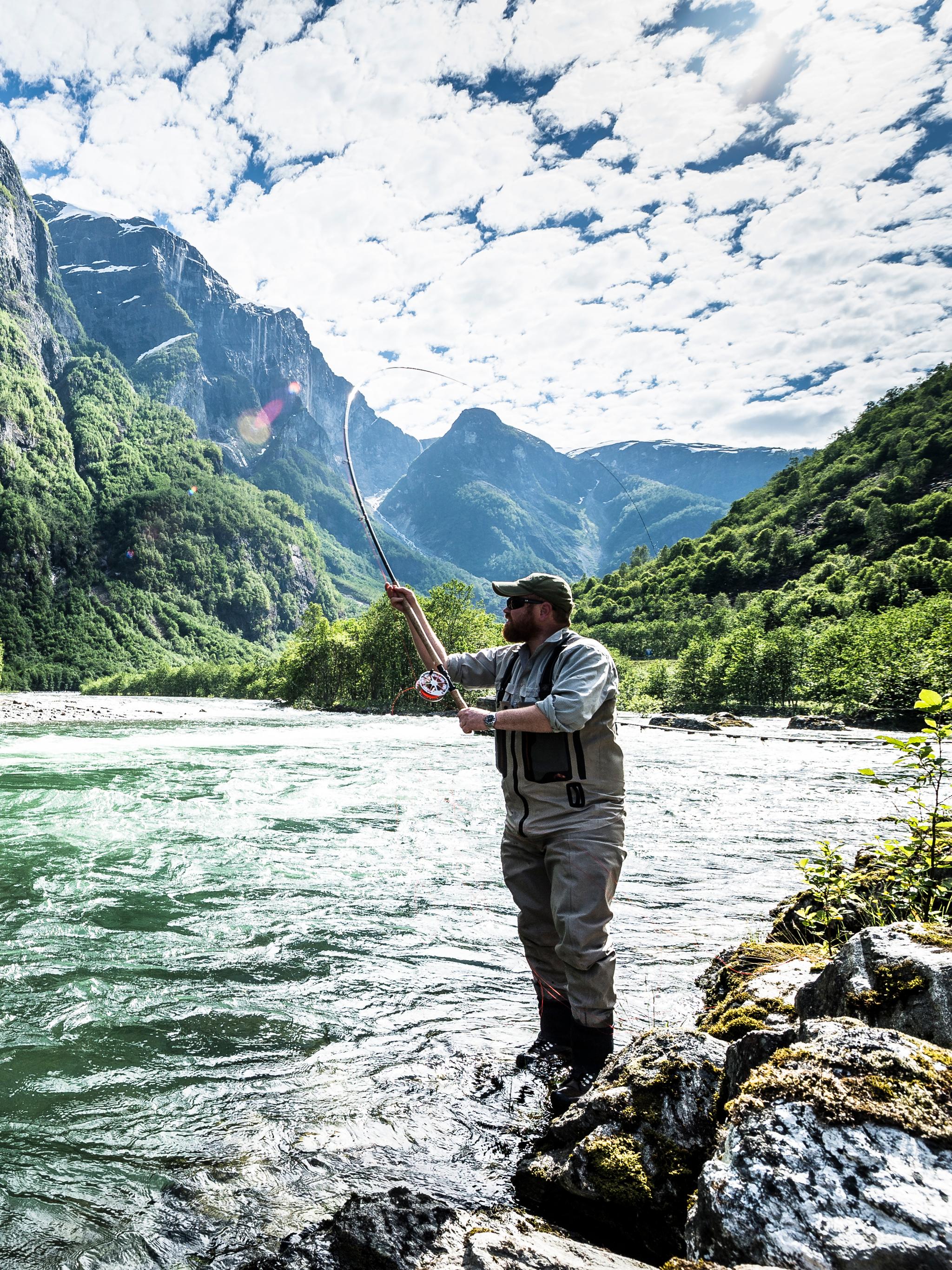 A man fishing for wild salmon in the Nærøydalselva in Fjord Norway
