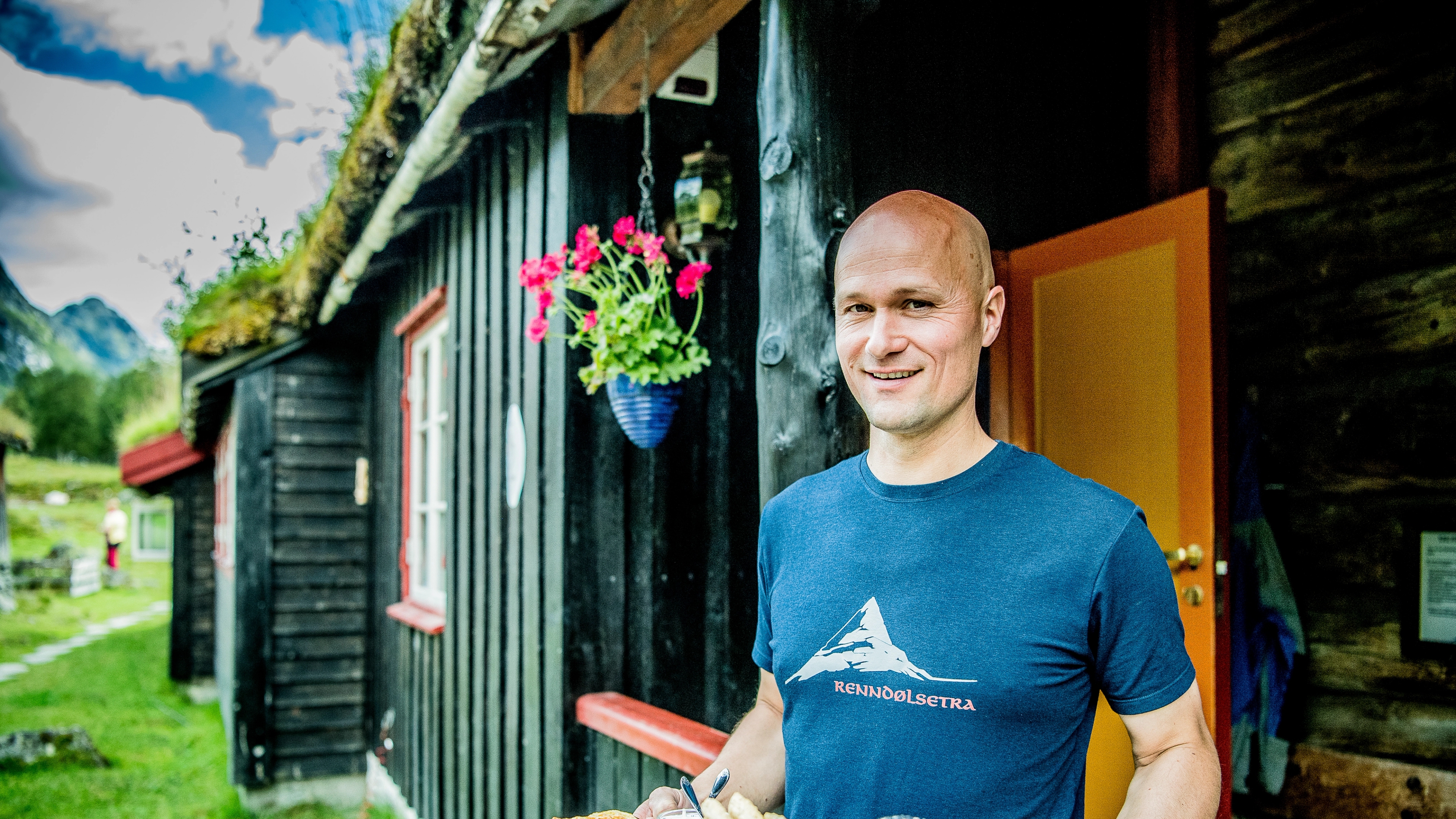 A man serving waffles at Renndølsetra in the Innerdalen valley in Northwest, Fjord Norway.