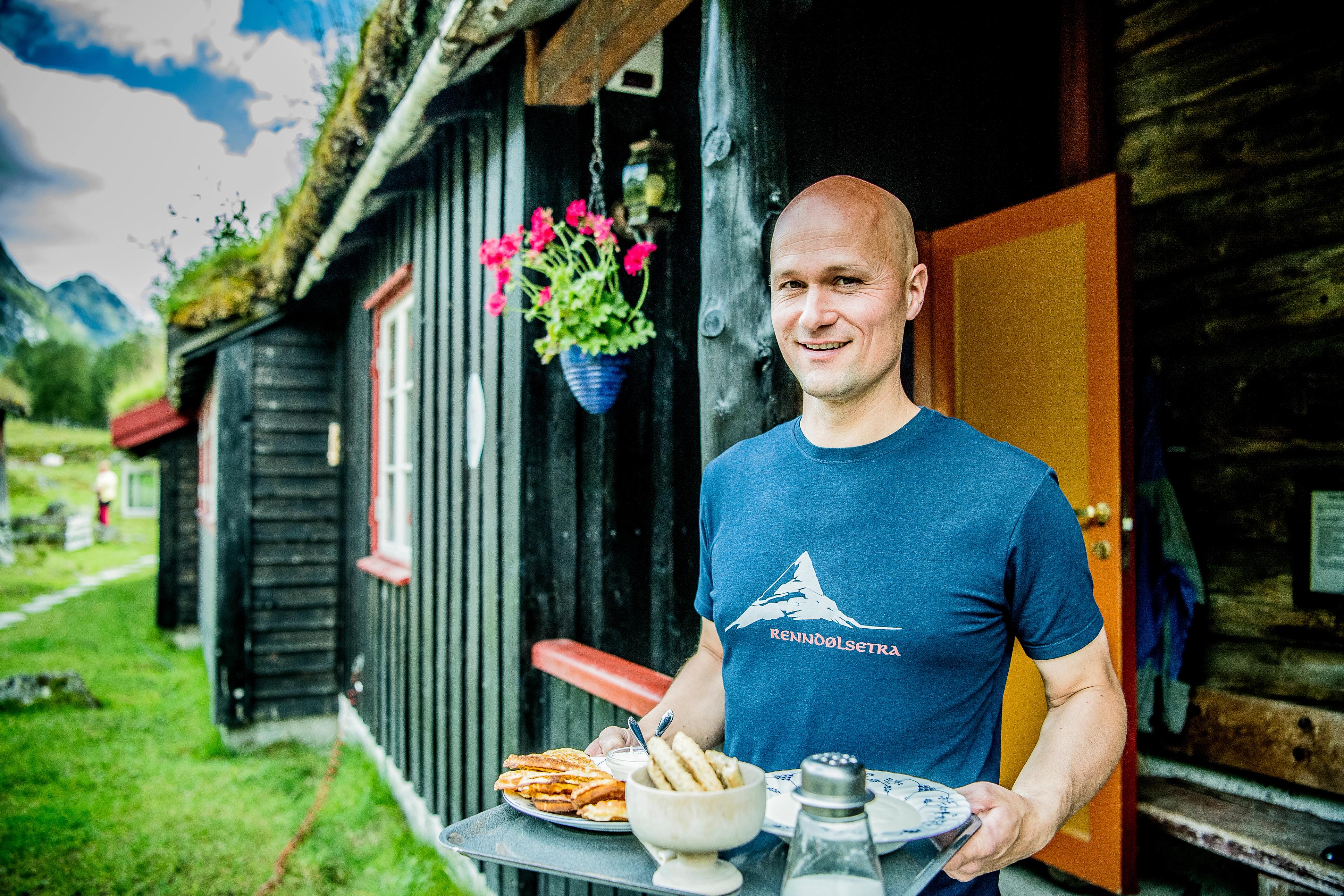 A man serving waffles at Renndølsetra in the Innerdalen valley in Northwest, Fjord Norway.