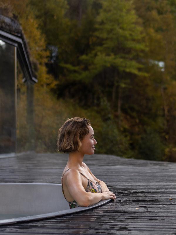 A women enjoying a bath in the spa area at Juvet Landskapshotell, Norway.