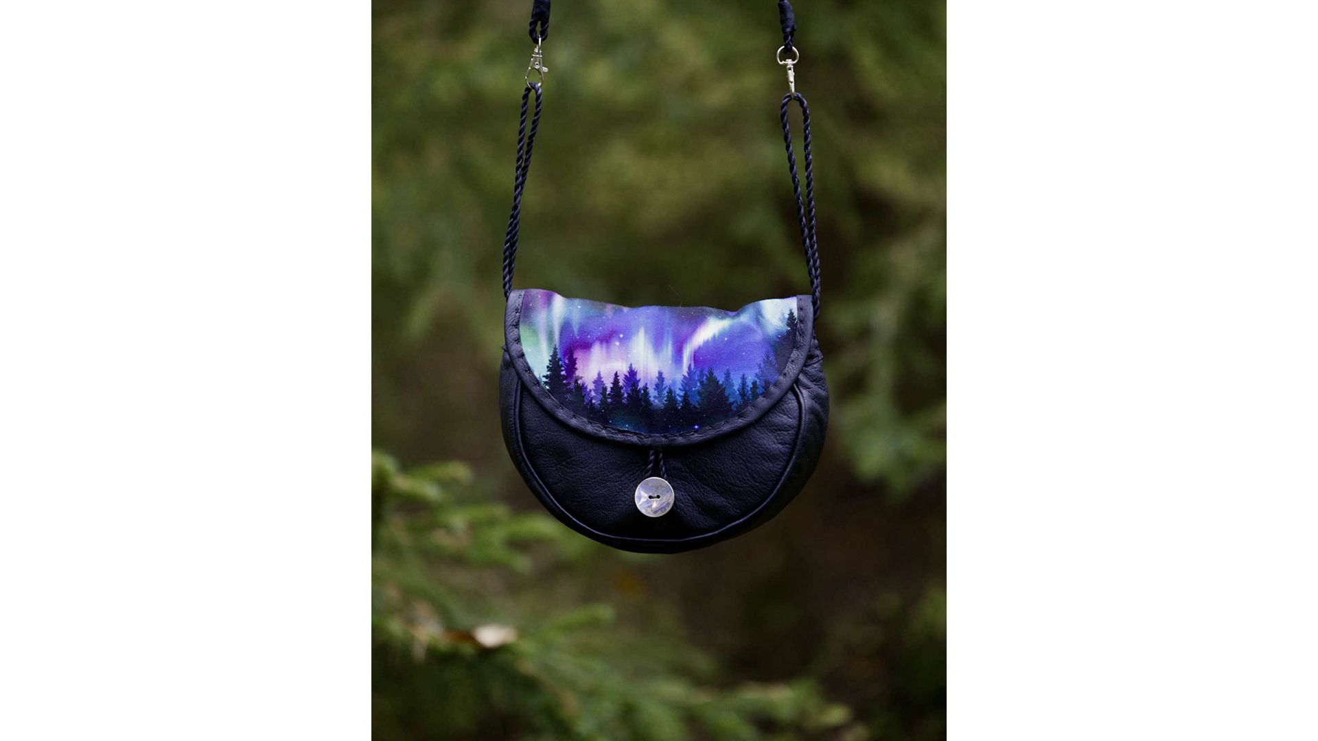 A black handbag with a colourful Northern lights pattern on the top flap.