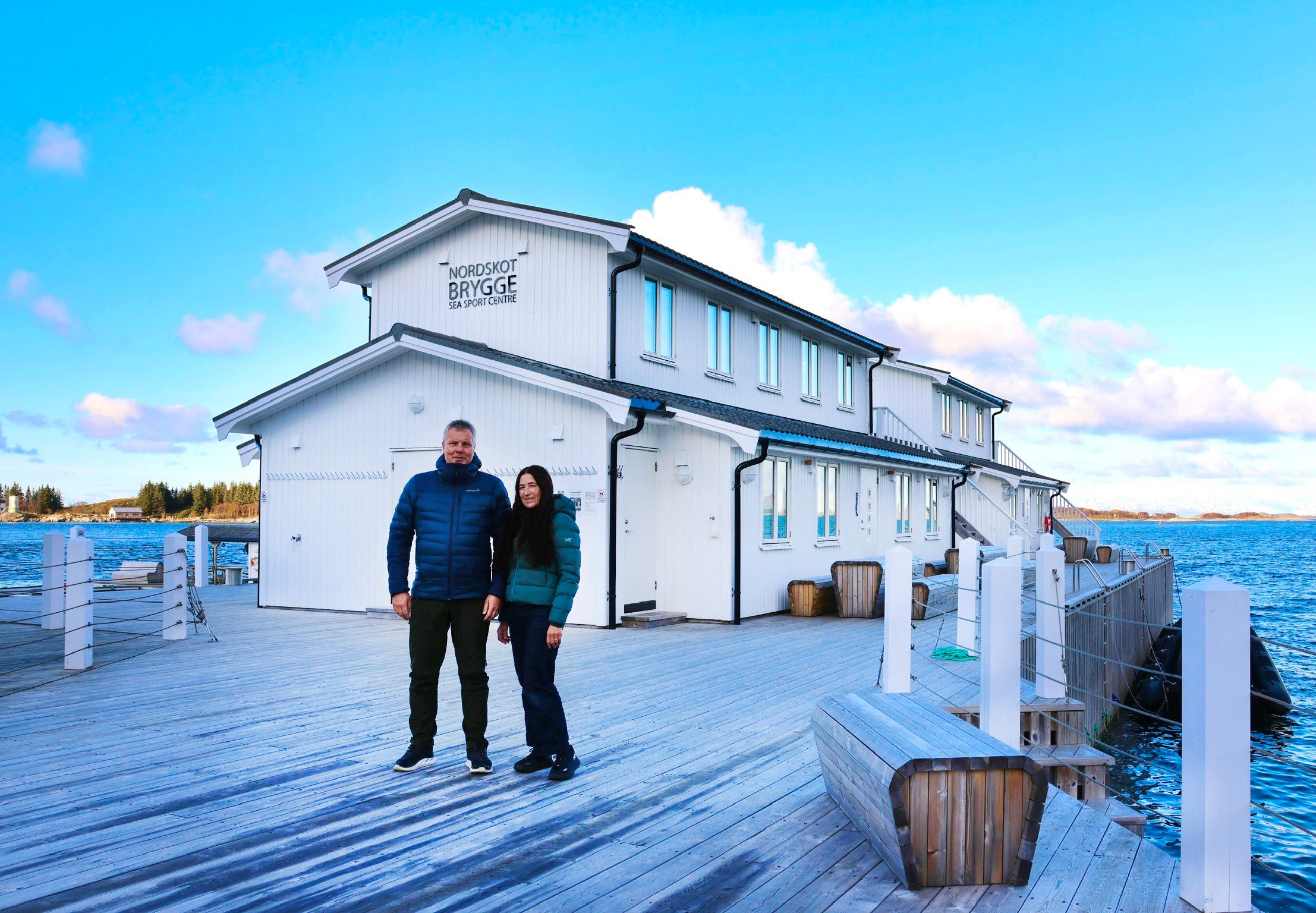 Couple in front of a white house by the sea