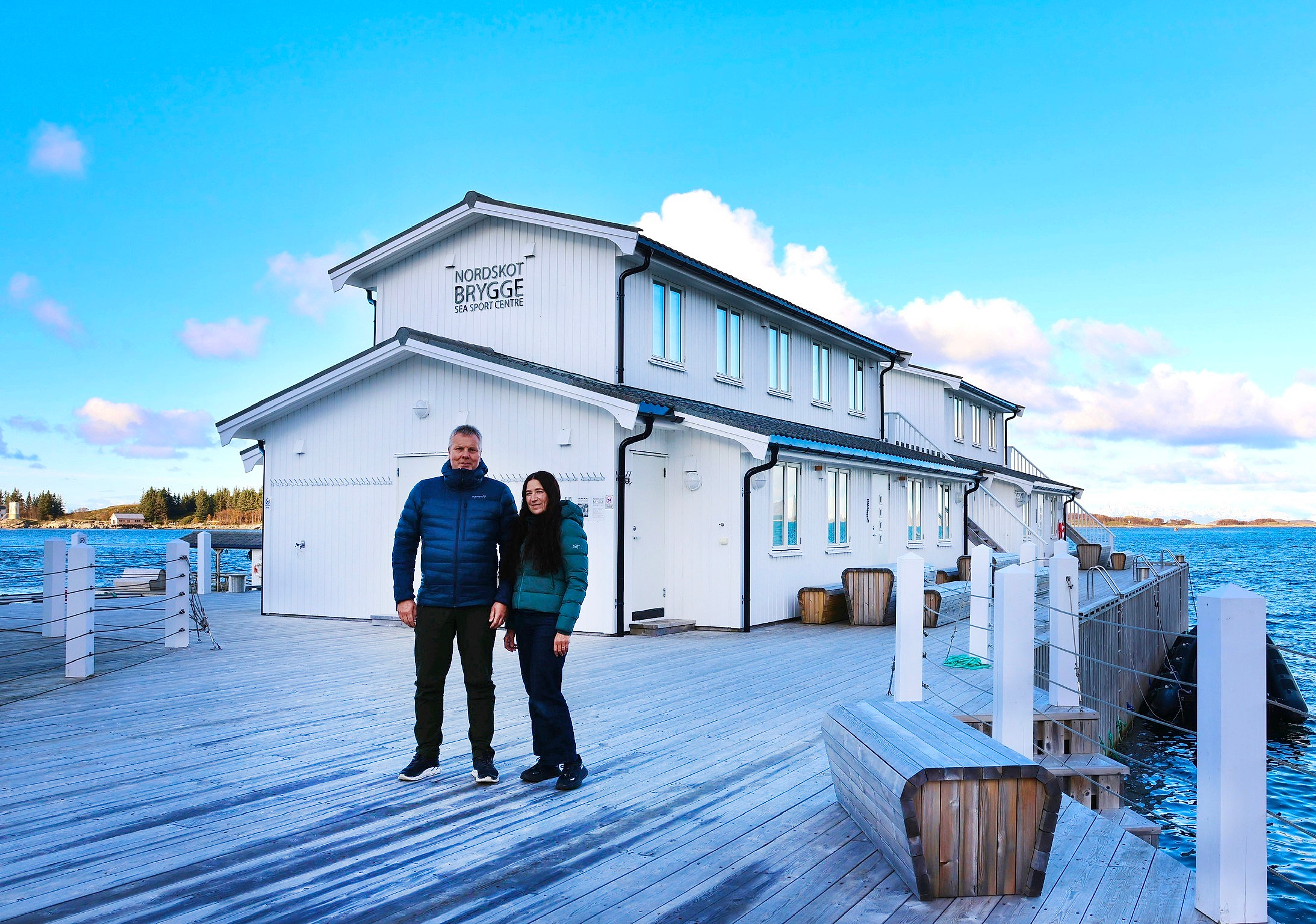 Couple in front of a white house by the sea