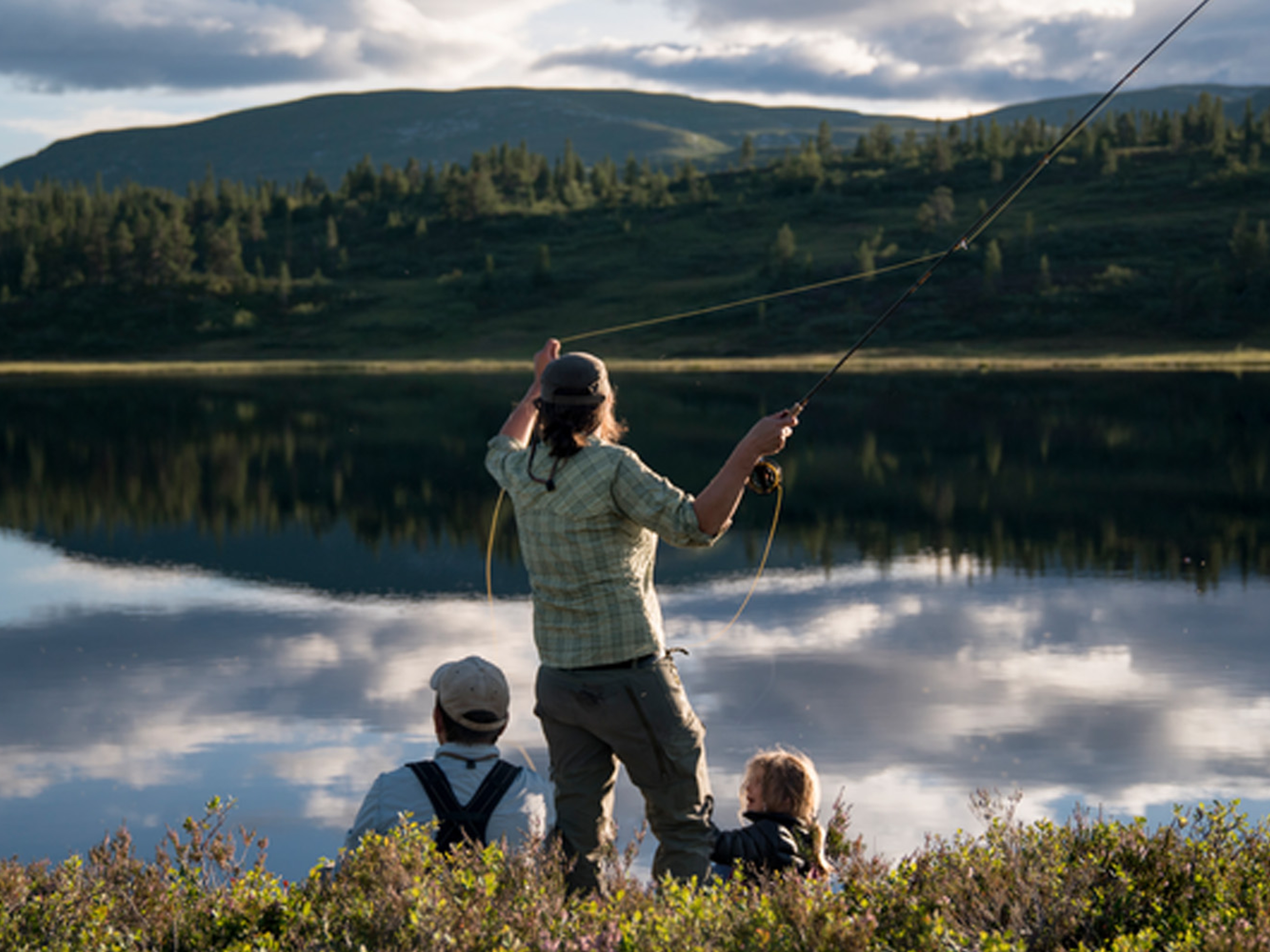 A woman and her family is fly-fishing in a lake in Blefjell, Eastern Norway
