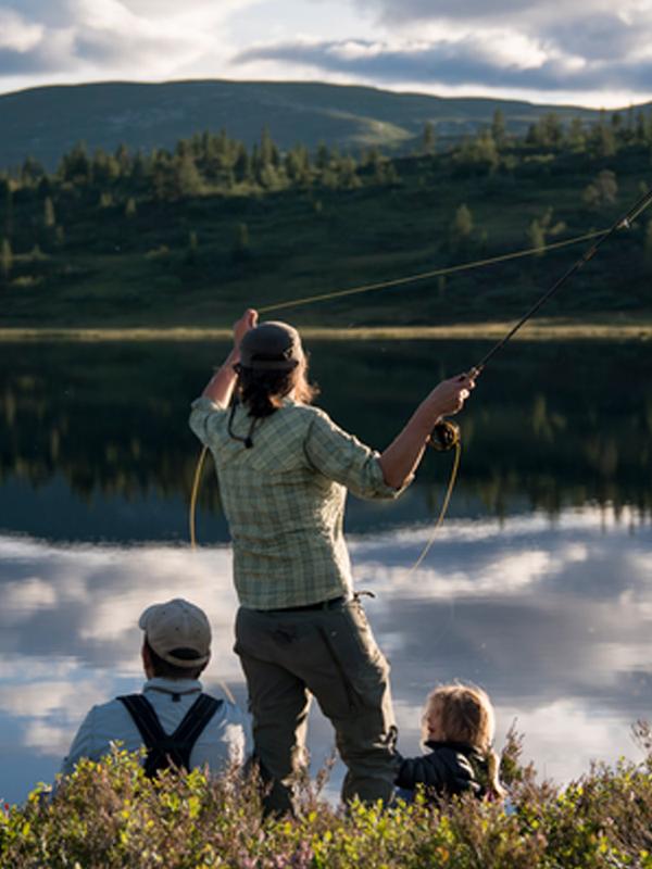 A woman and her family is fly-fishing in a lake in Blefjell, Eastern Norway