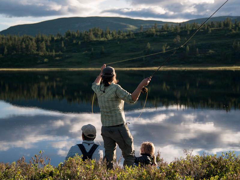 A woman and her family is fly-fishing in a lake in Blefjell, Eastern Norway