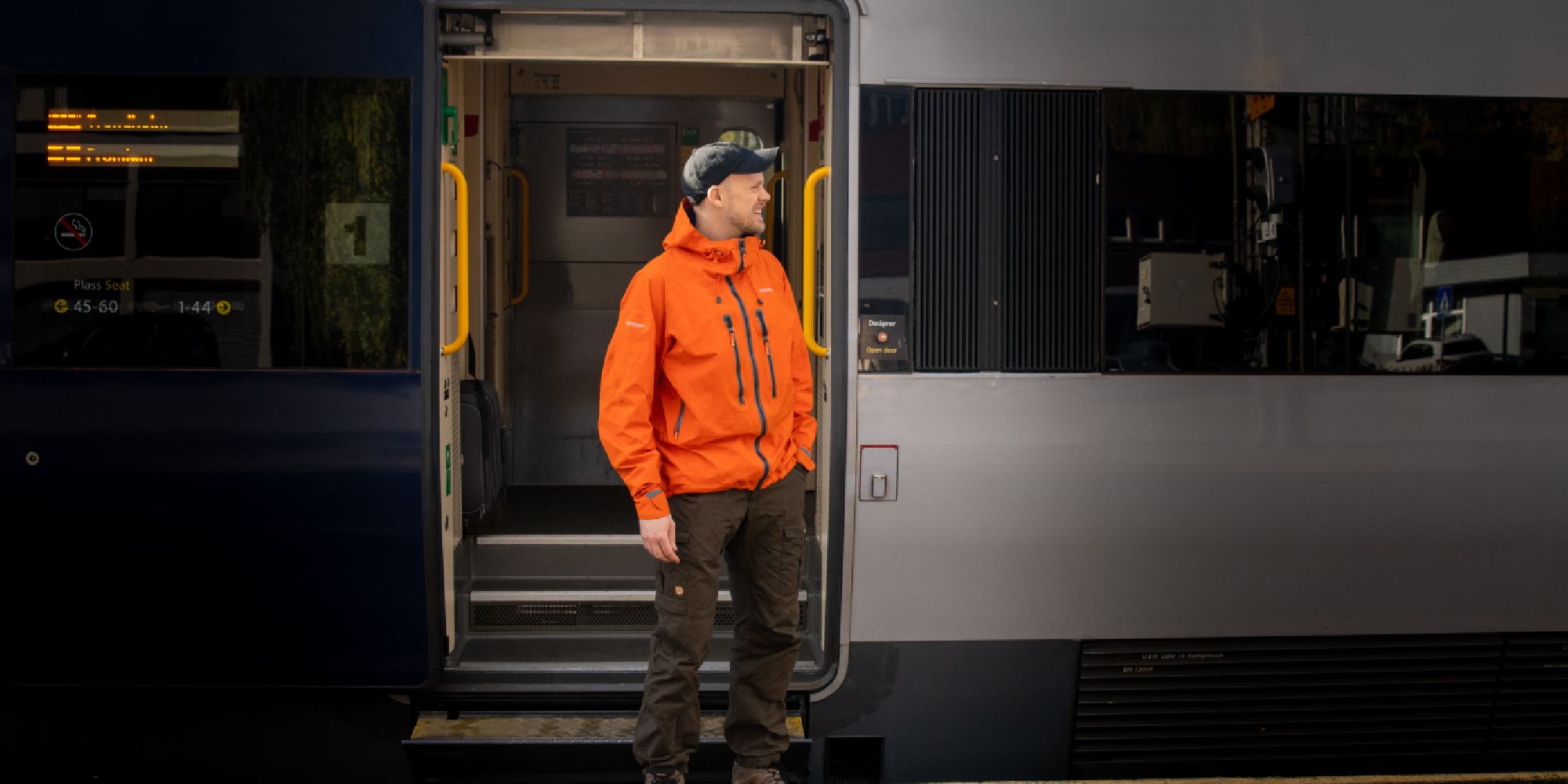 A man getting on board on the Dovre Railway train.