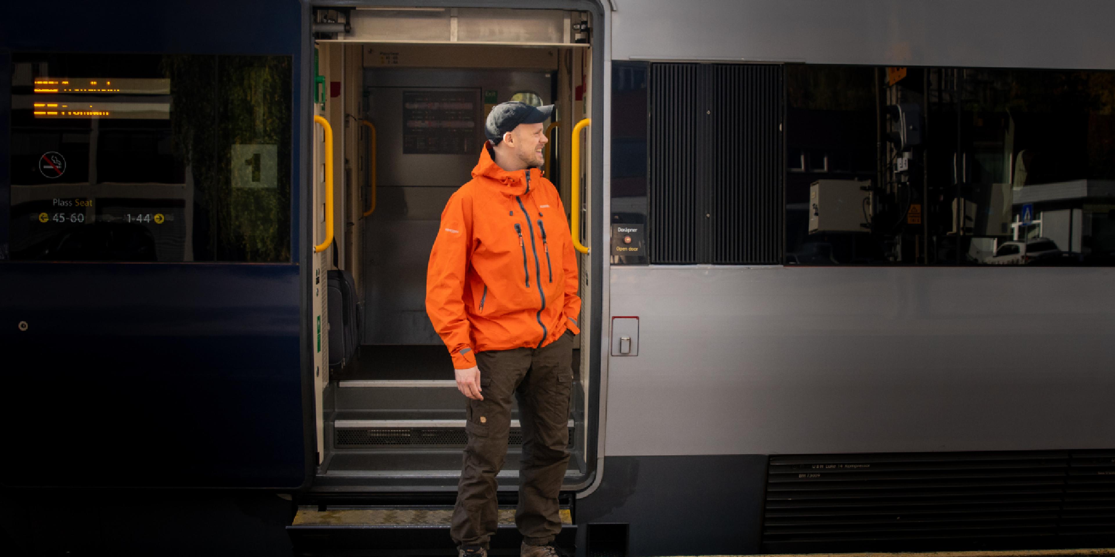 A man getting on board on the Dovre Railway train.