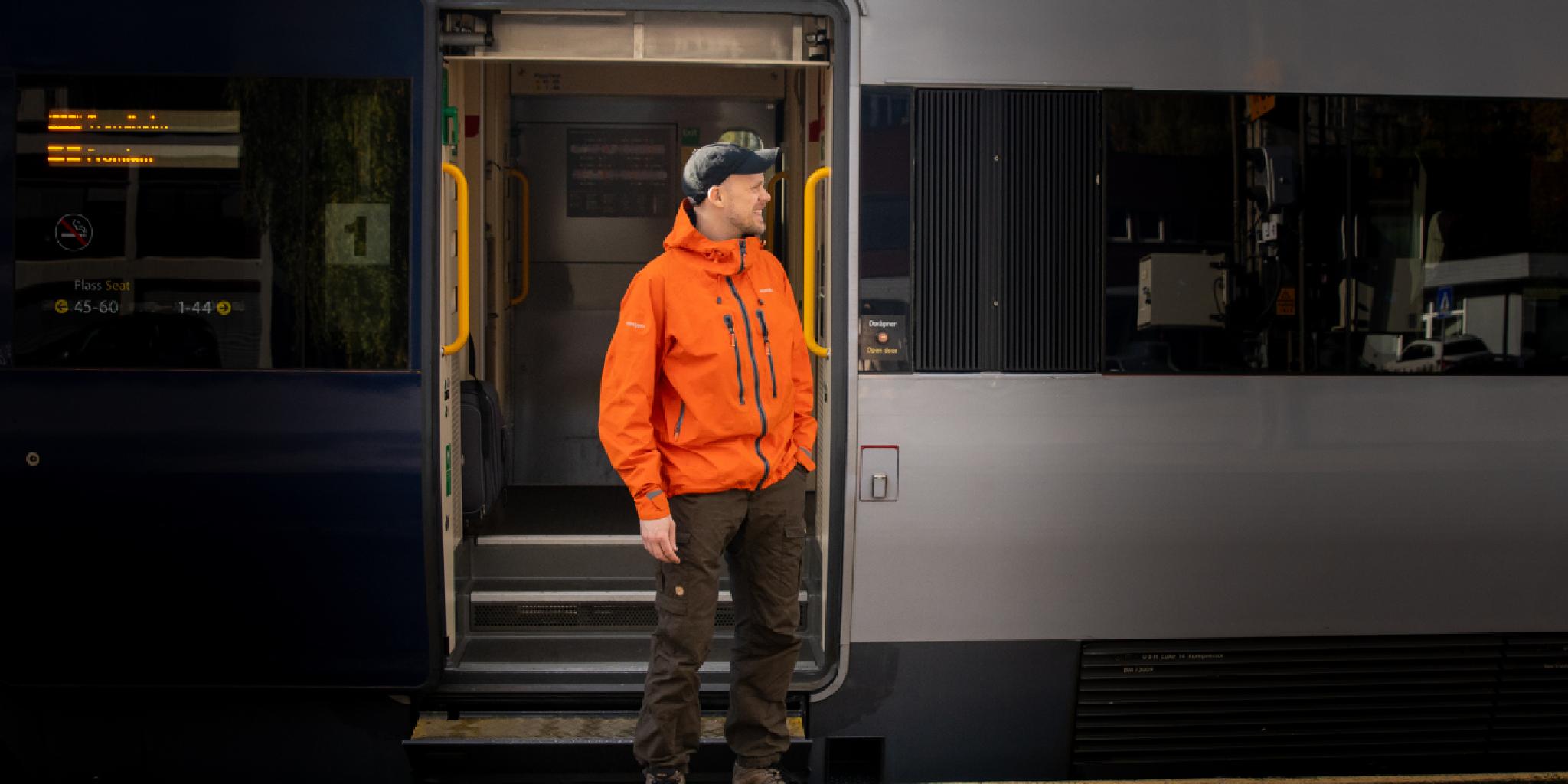 A man getting on board on the Dovre Railway train.