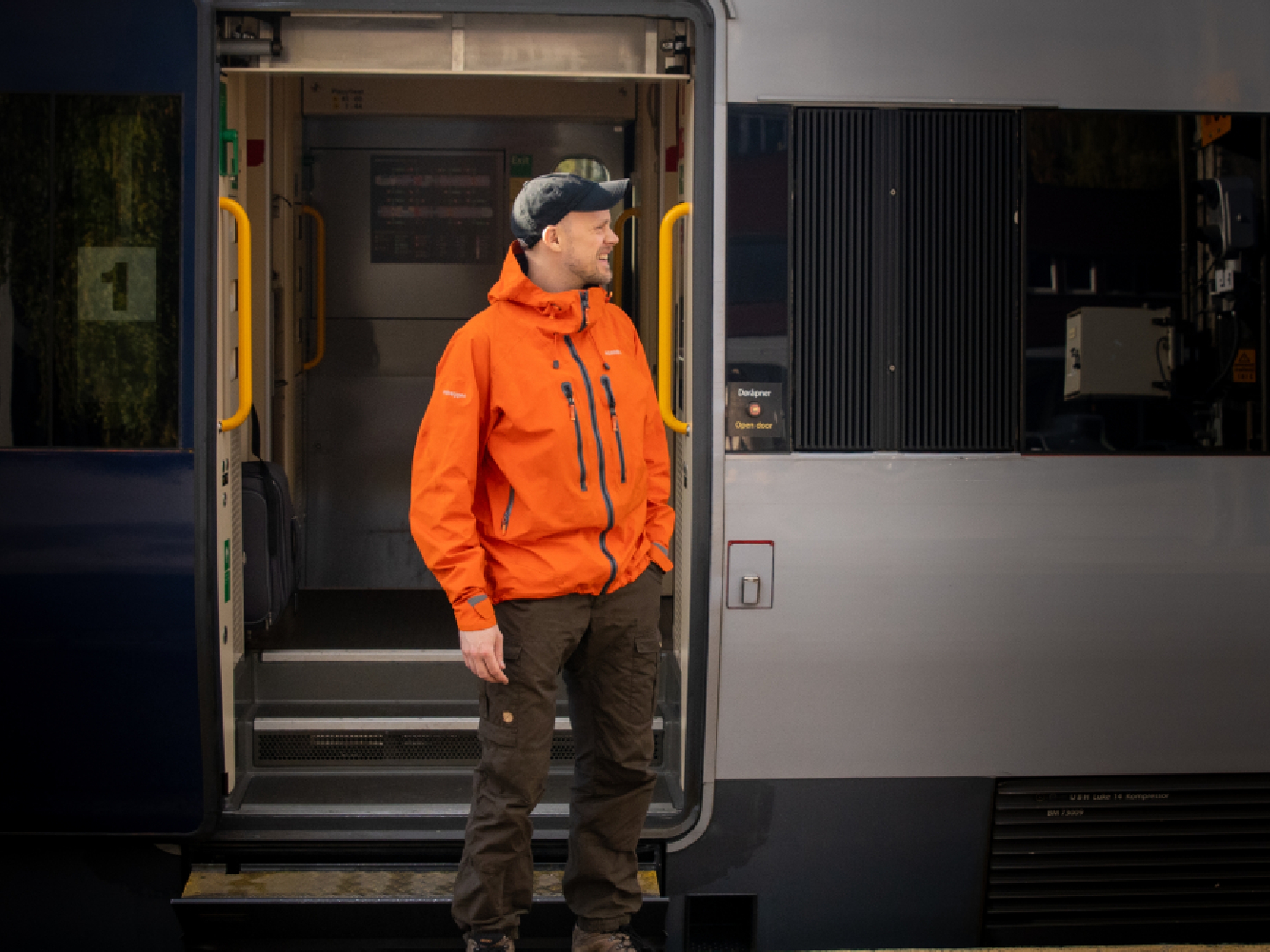 A man getting on board on the Dovre Railway train.