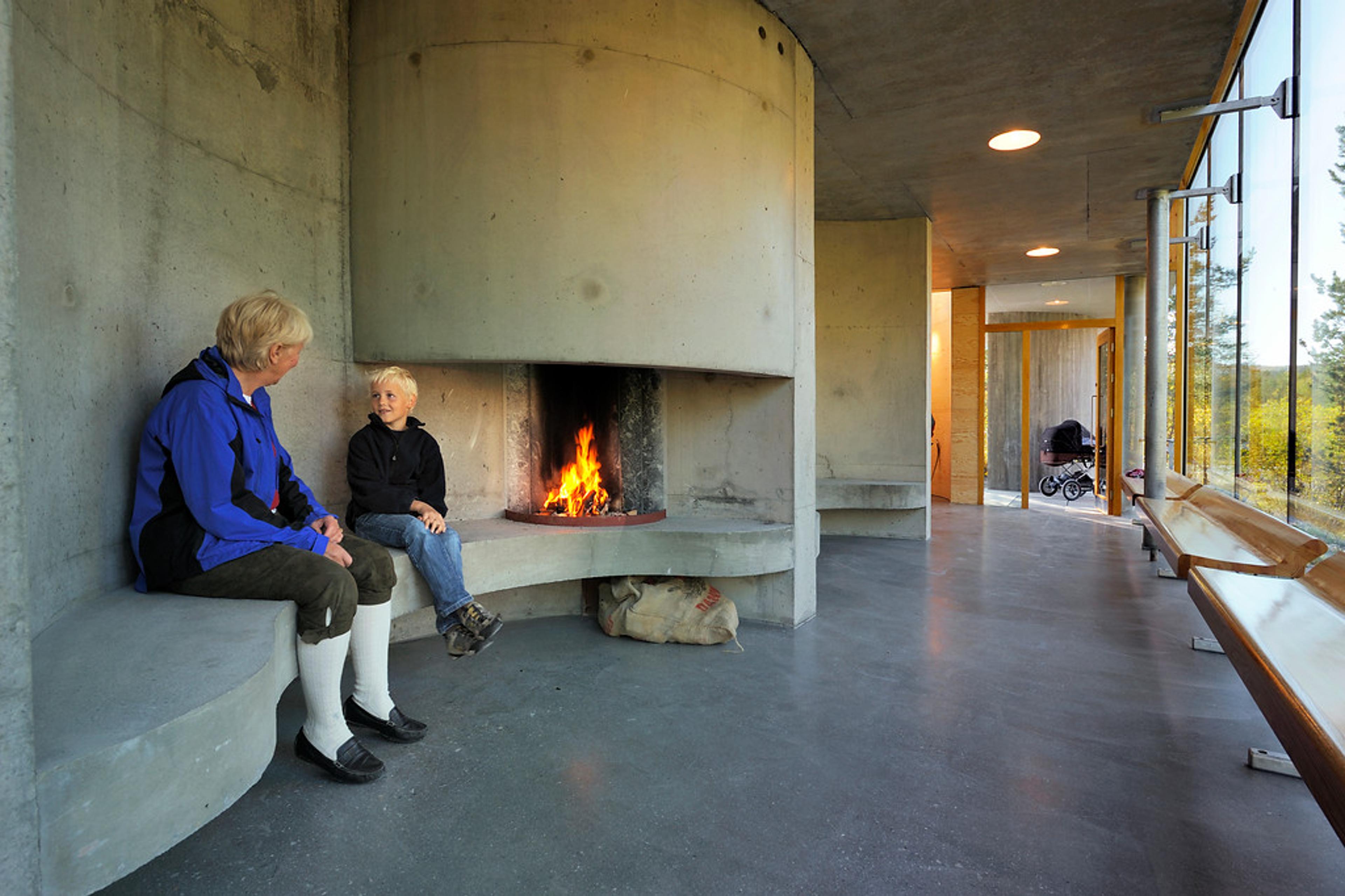 People enjoying a warm fire in a concrete building