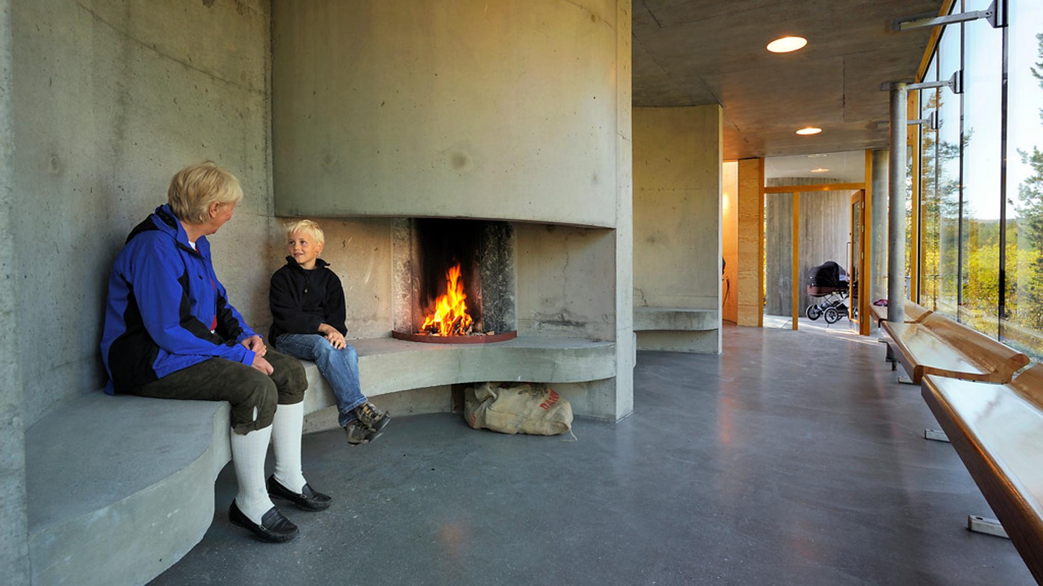 People enjoying a warm fire in a concrete building