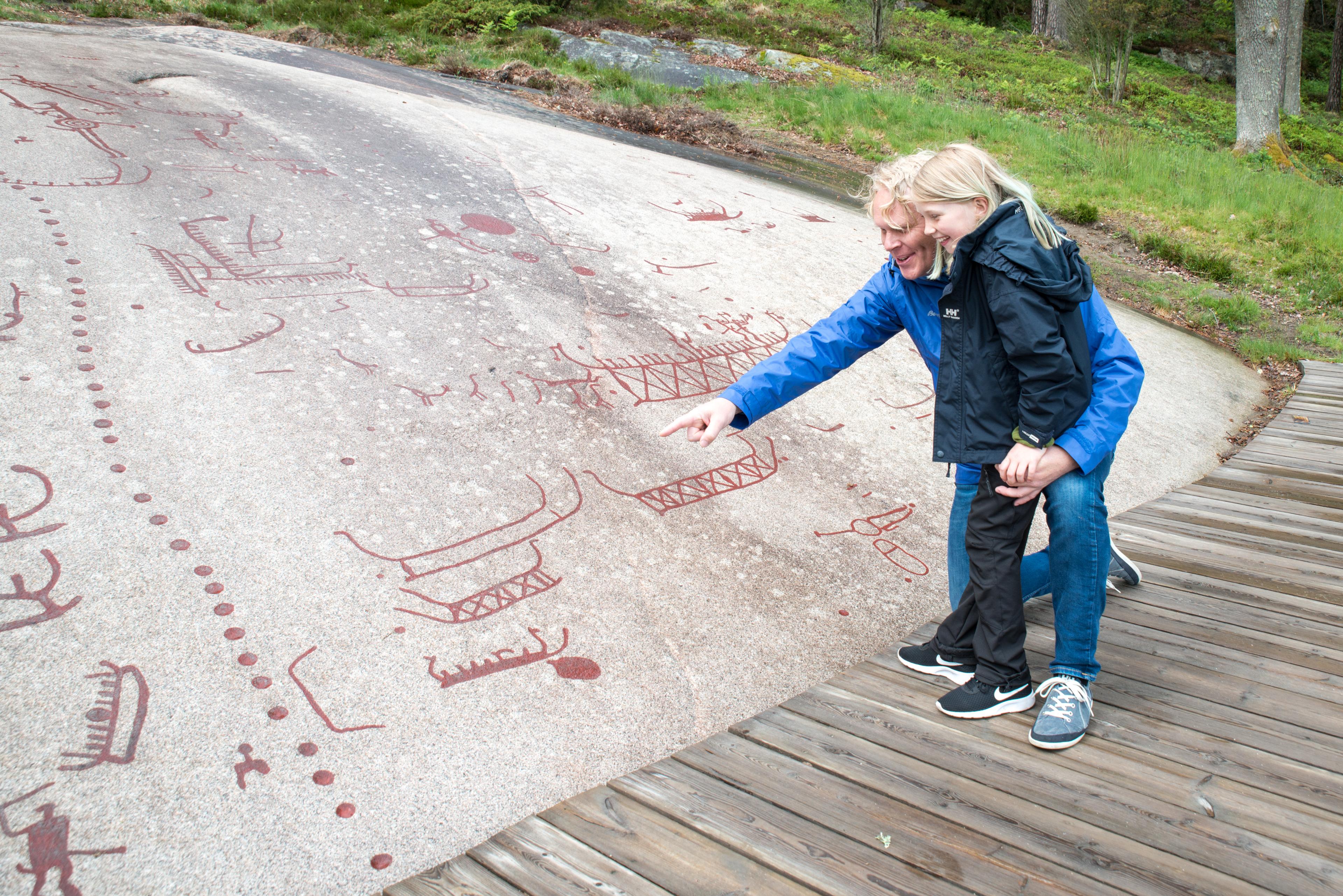 People looking at the petroglyphs in Sarpsborg in Østfold, Eastern Norway