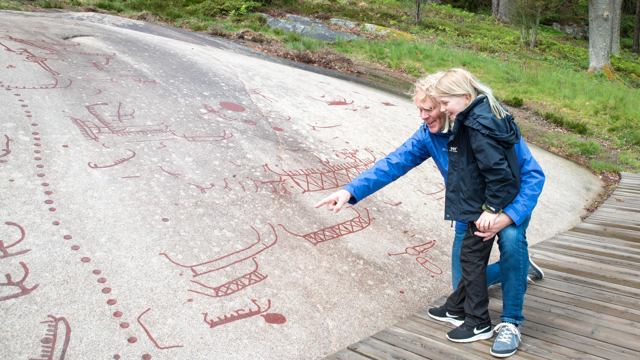 People looking at the petroglyphs in Sarpsborg in Østfold, Eastern Norway