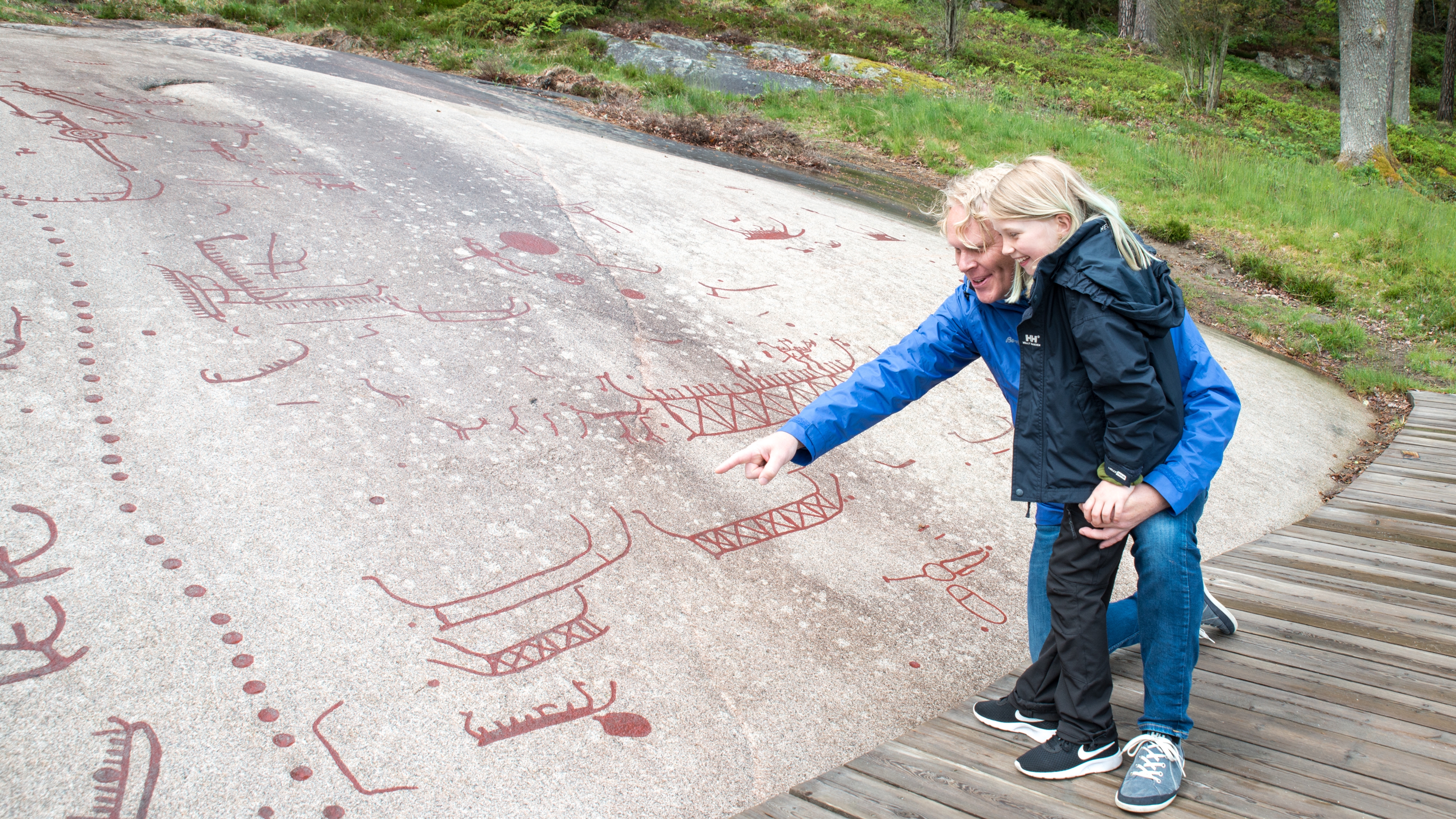 Folk ser på helleristninger i Sarpsborg i Østfold på Østlandet