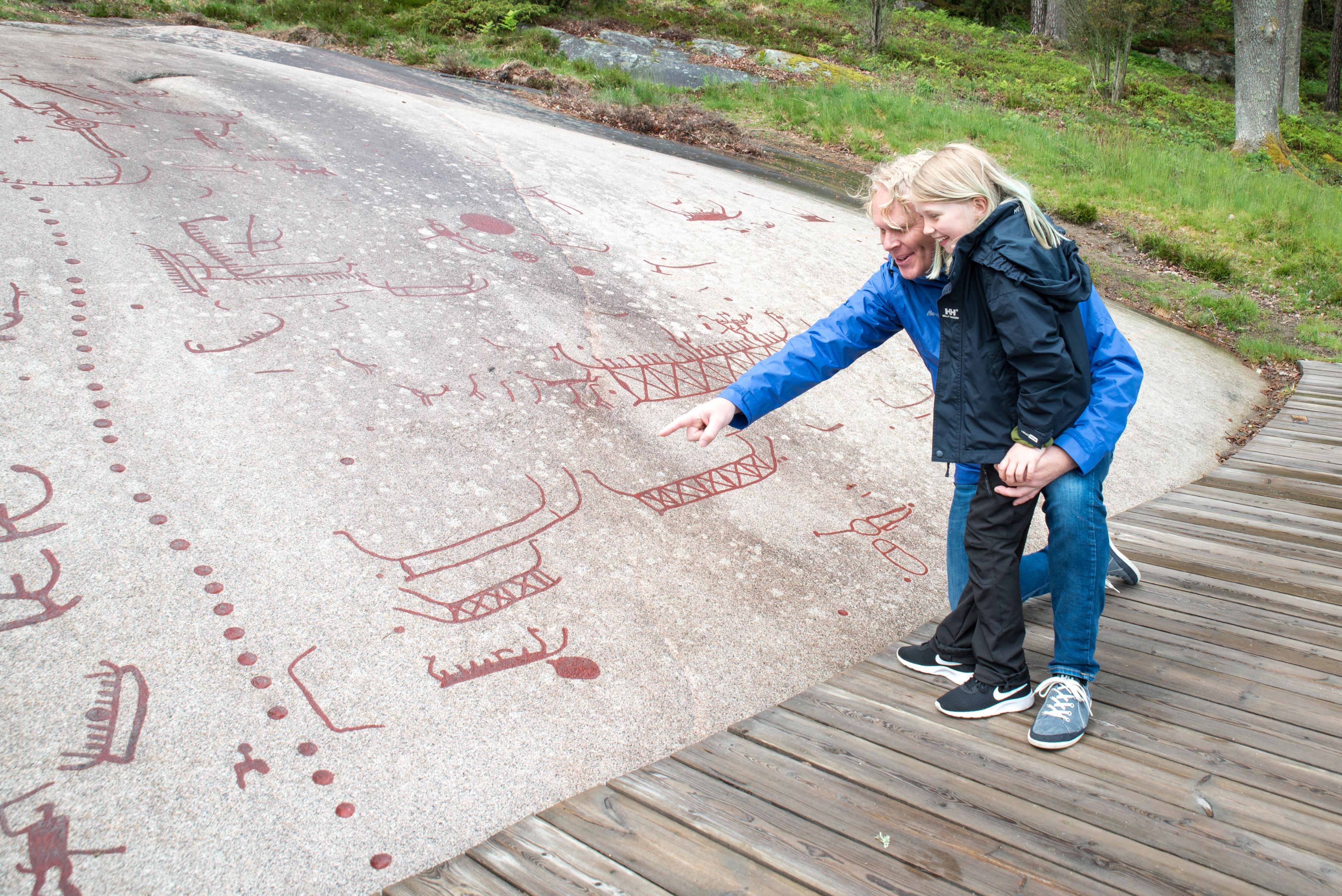 People looking at the petroglyphs in Sarpsborg in Østfold, Eastern Norway