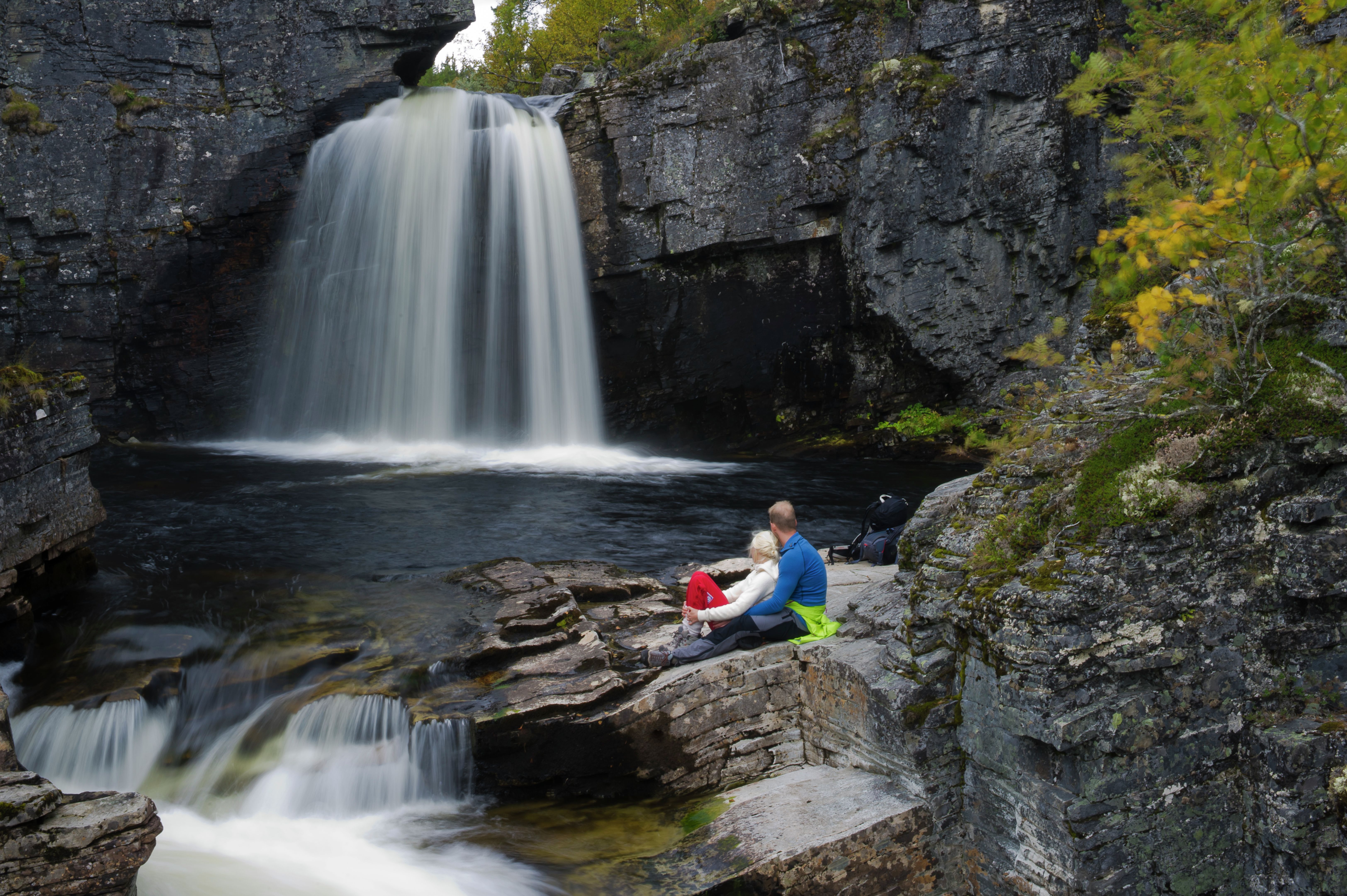 A couple looking at the waterfall Myfallene