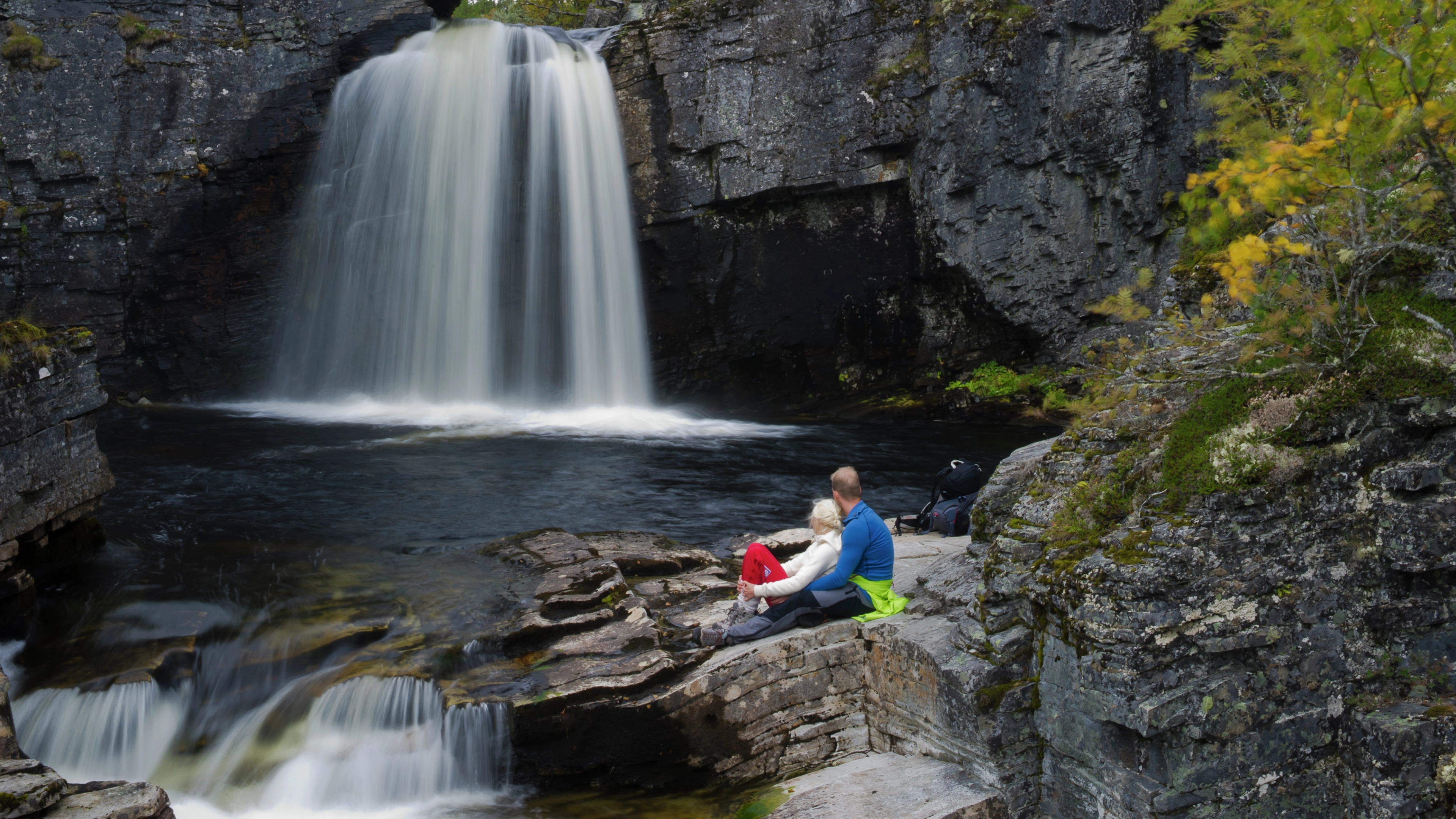 A couple looking at the waterfall Myfallene