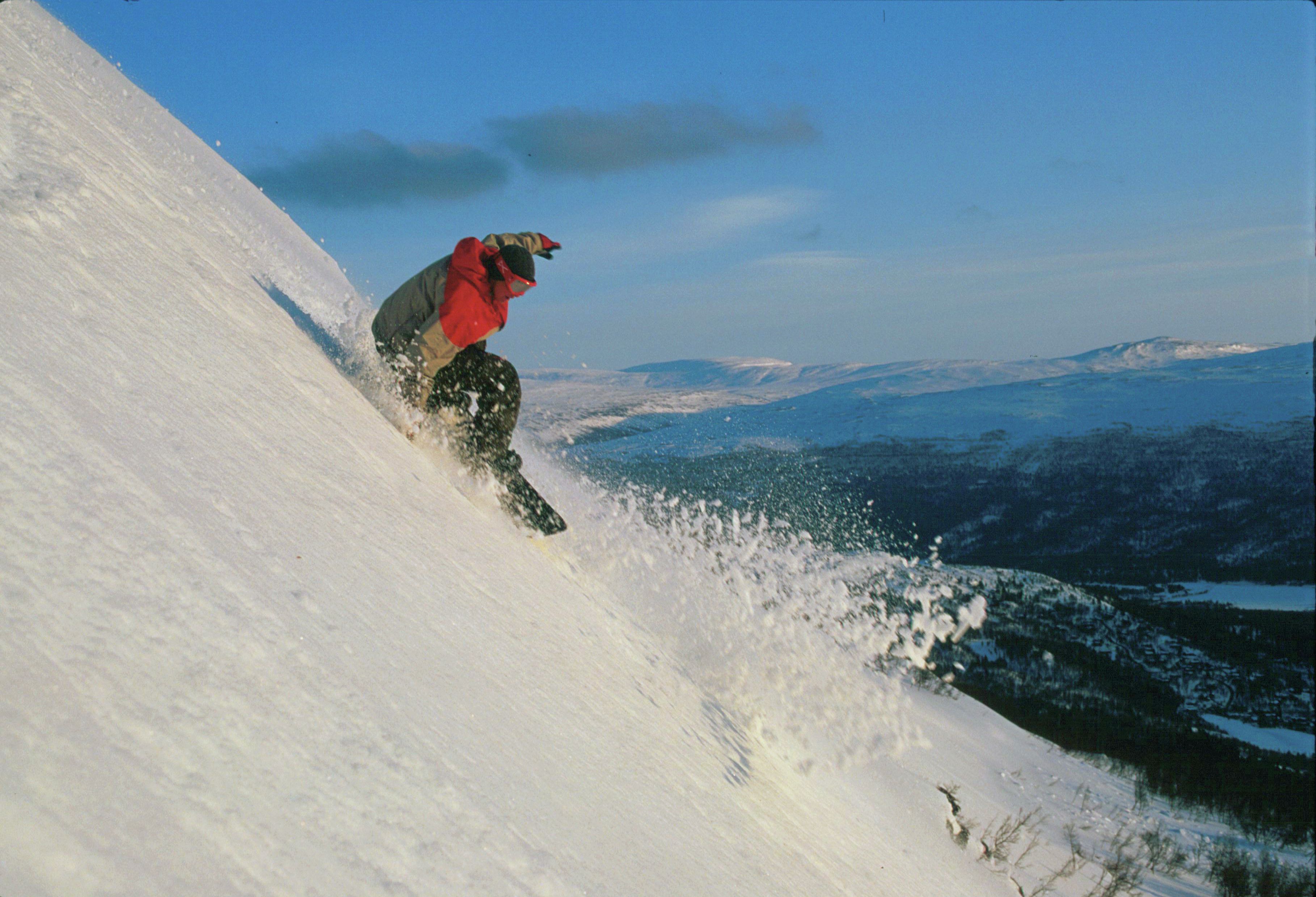 A man is snowboarding at Bjorli