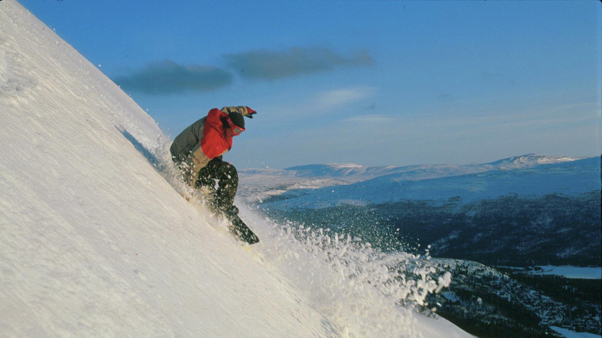 A man is snowboarding at Bjorli