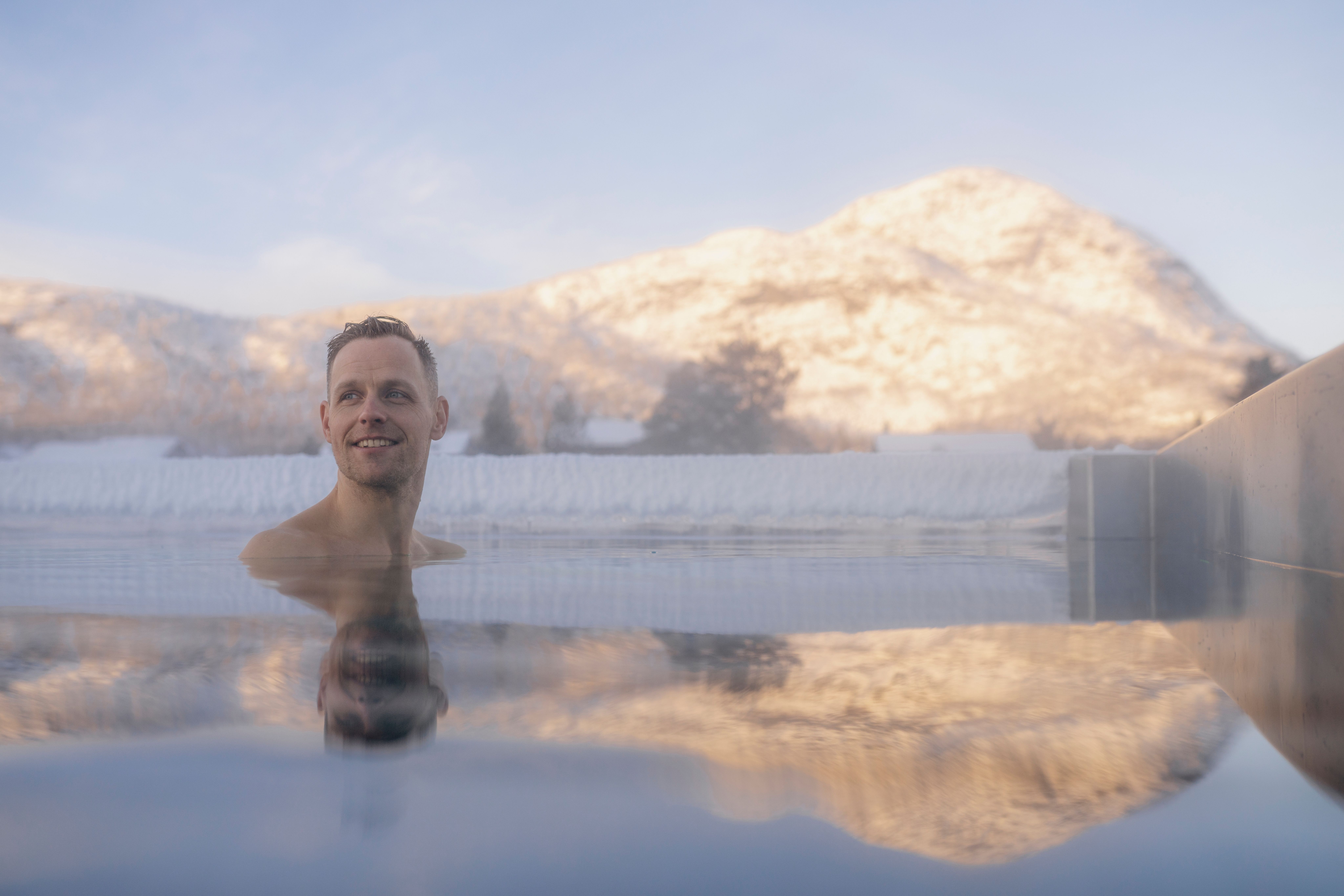 A person swimming in the outside pool during winter at Hovden fjellbad spa in Hovden