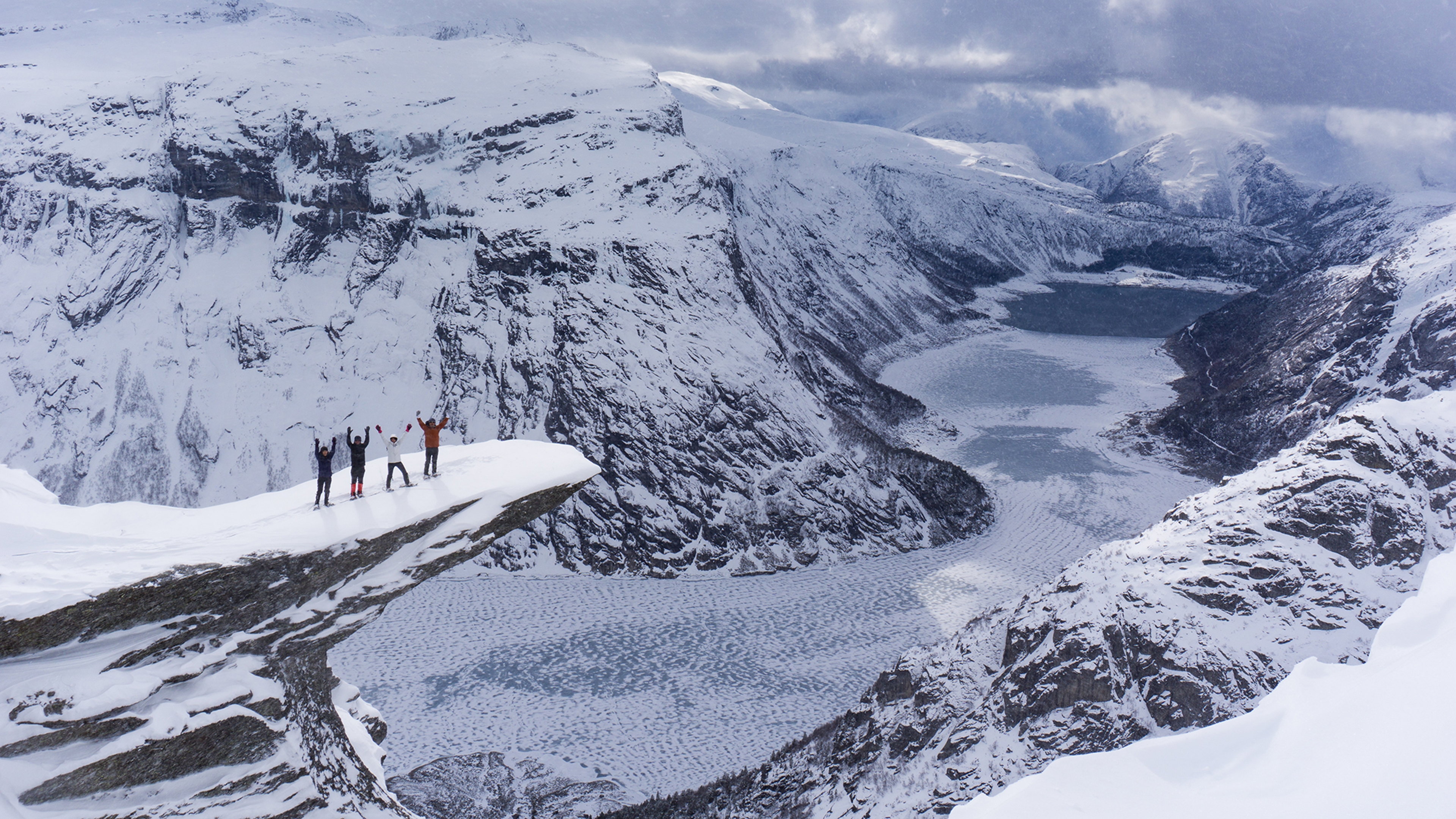 Four people with snowshoes at Trolltunga in Fjord Norway