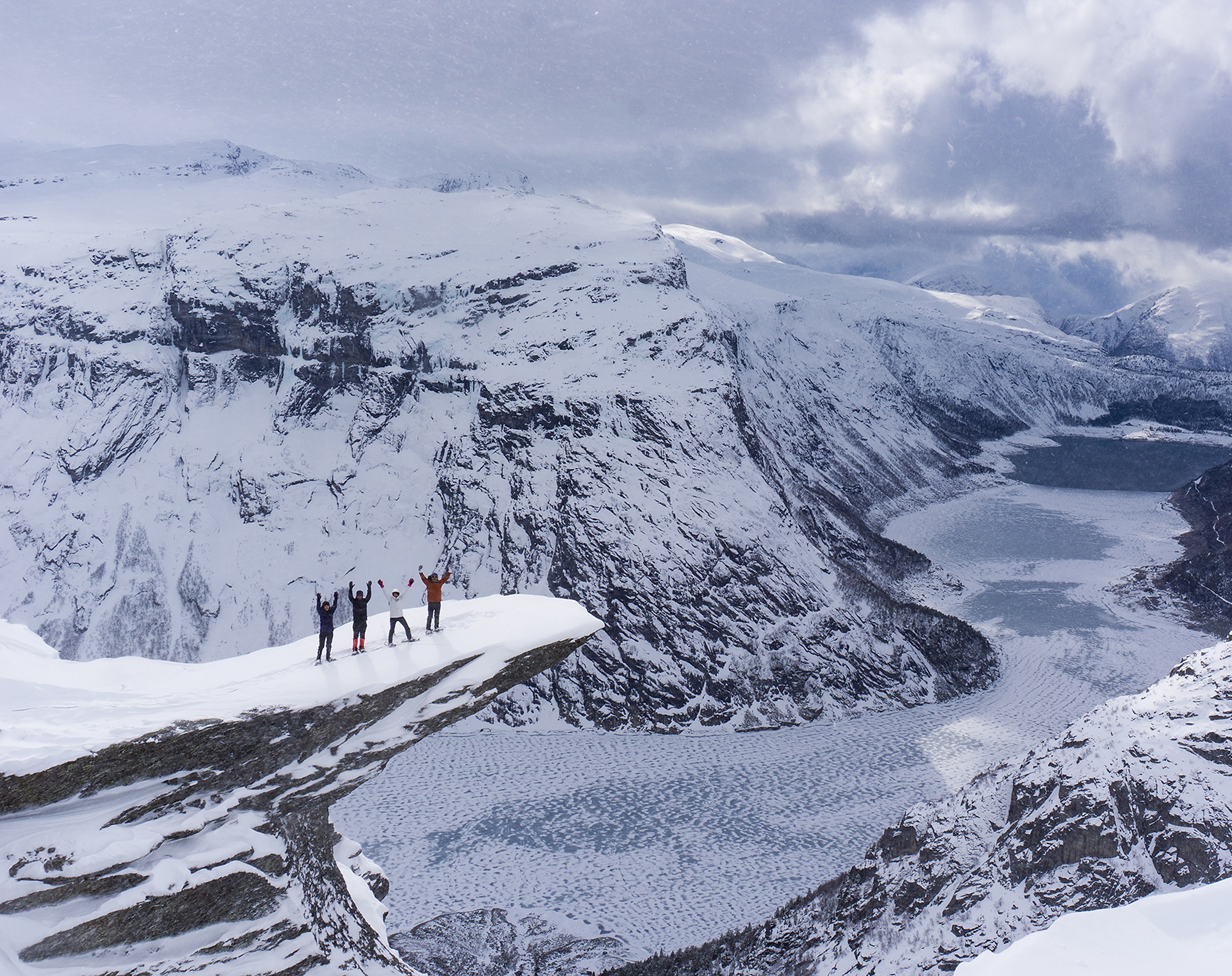 Four people with snowshoes at Trolltunga in Fjord Norway