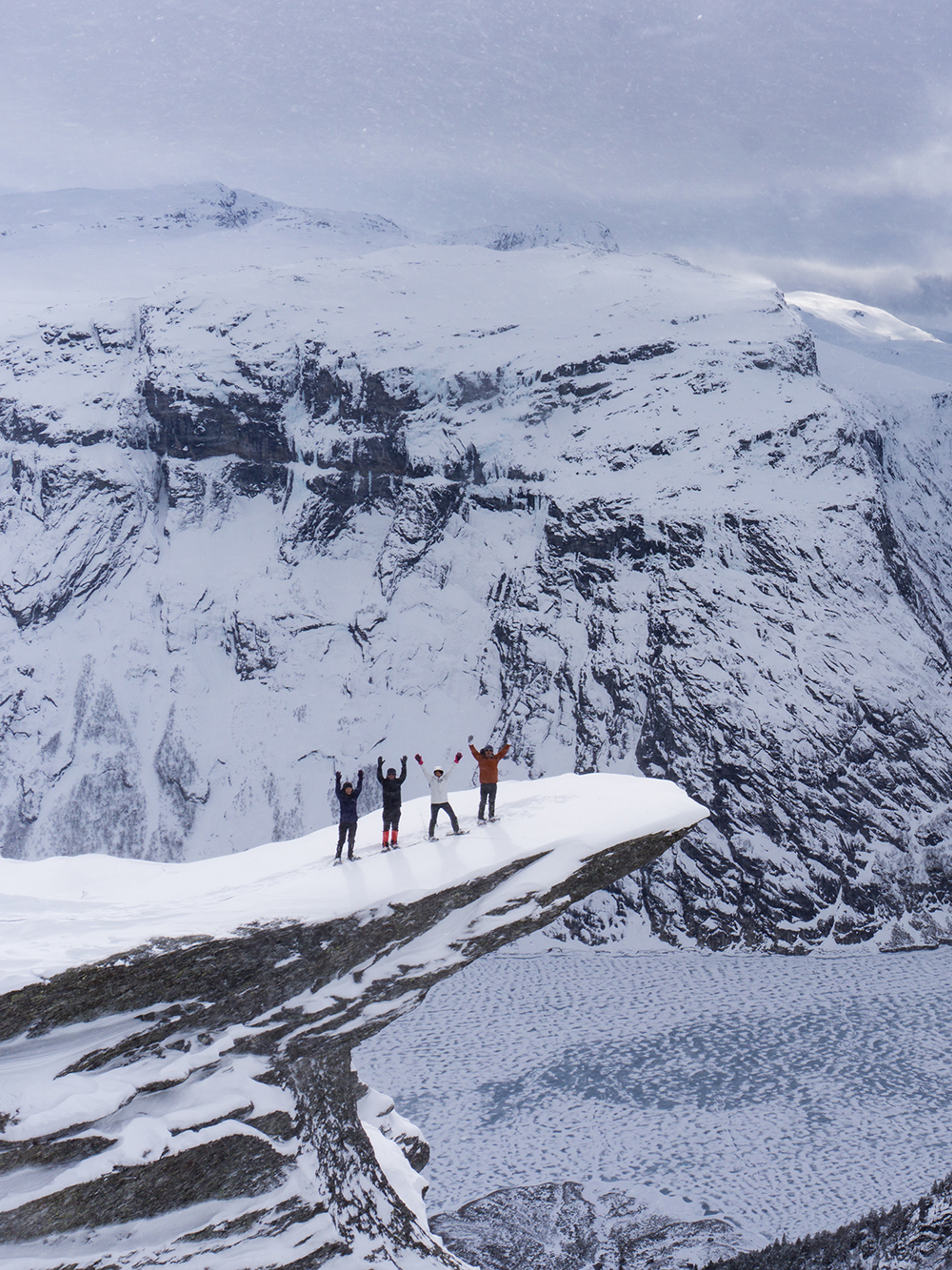 Four people with snowshoes at Trolltunga in Fjord Norway
