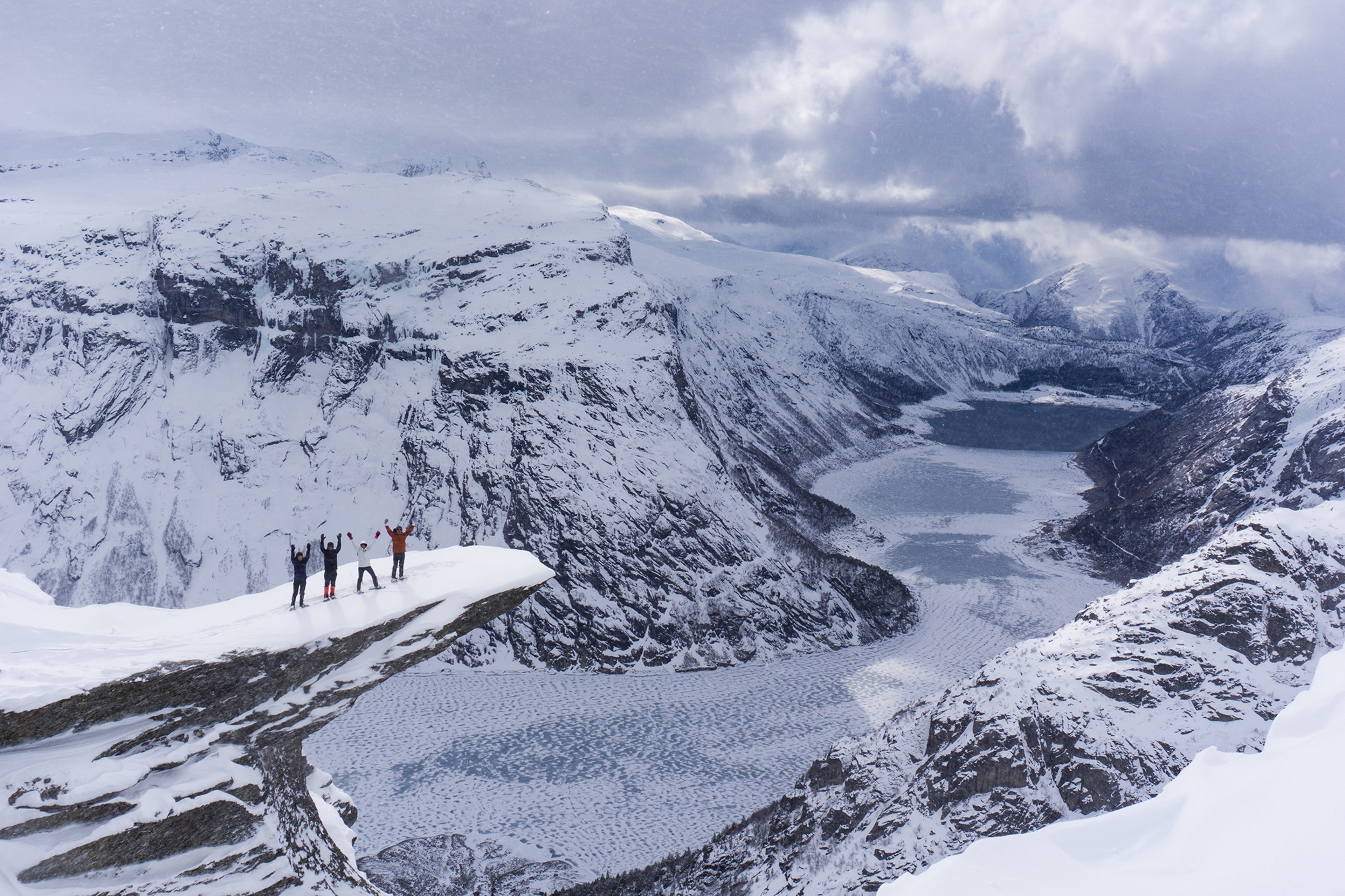 Four people with snowshoes at Trolltunga in Fjord Norway