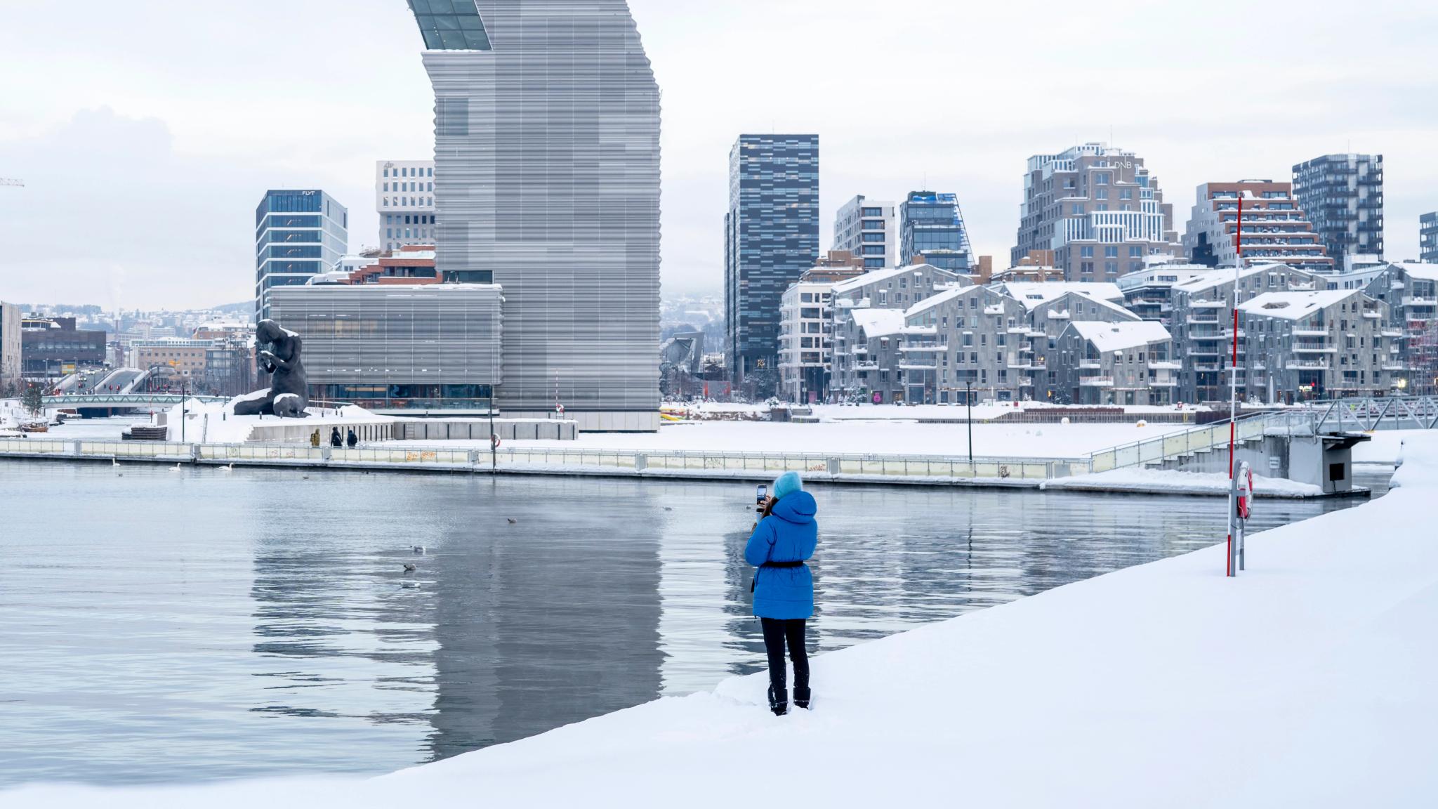 Woman in front of buildings like the MUNCH museum in Bjørvika in Oslo