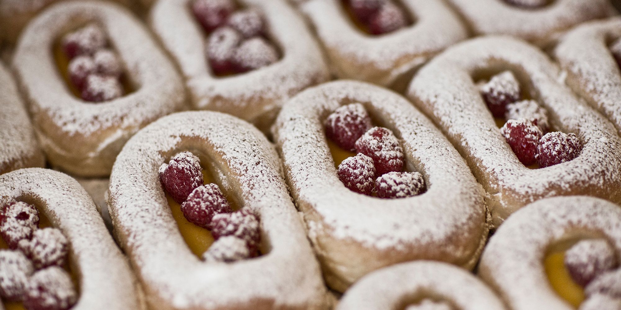 Buns on a tray filled with berries and custard
