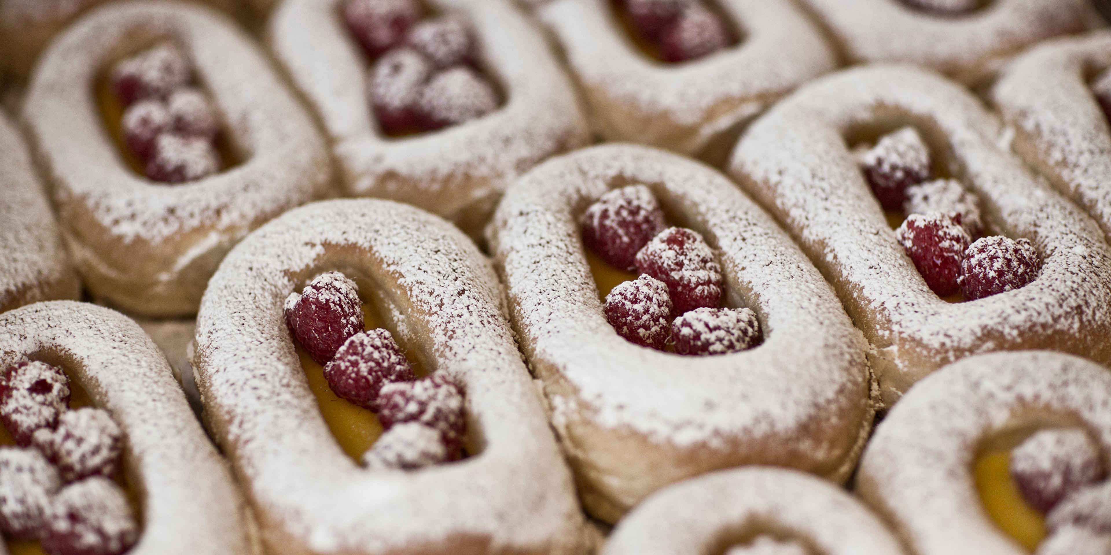 Buns on a tray filled with berries and custard