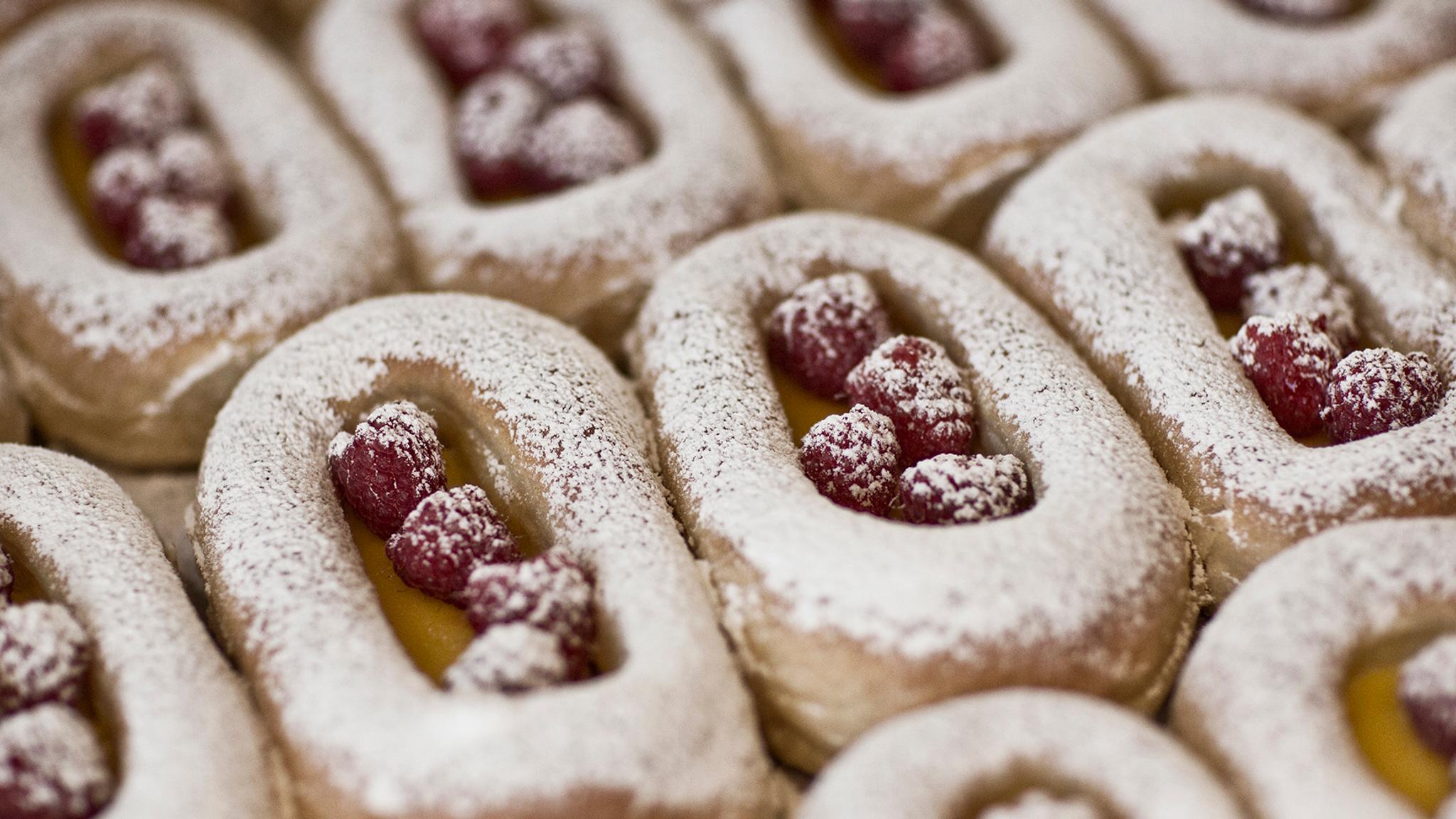 Buns on a tray filled with berries and custard