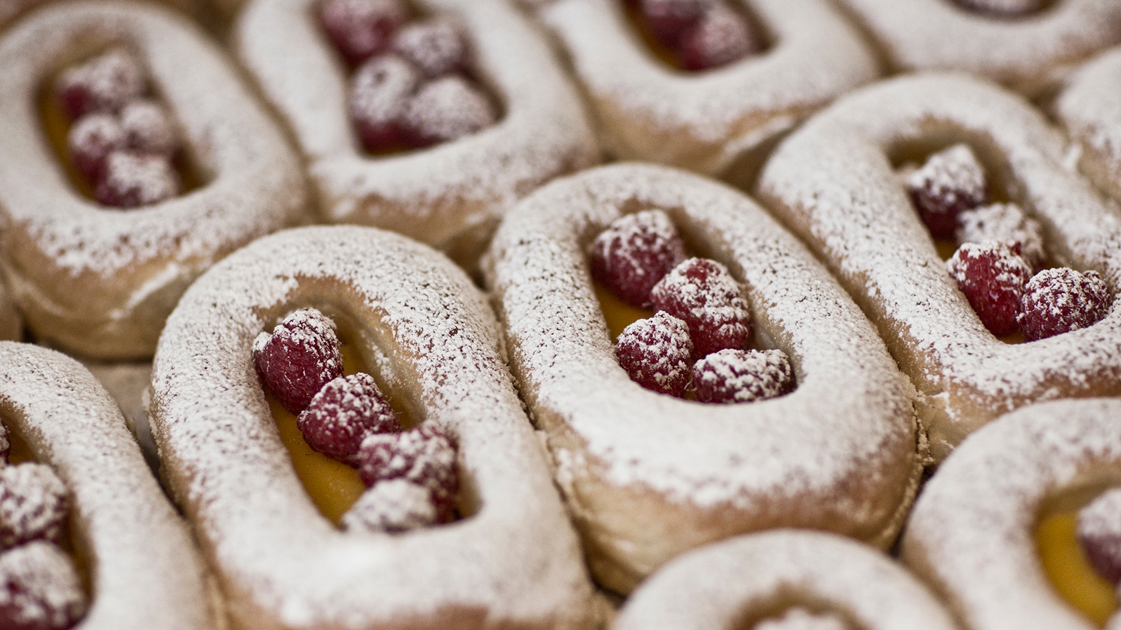 Buns on a tray filled with berries and custard