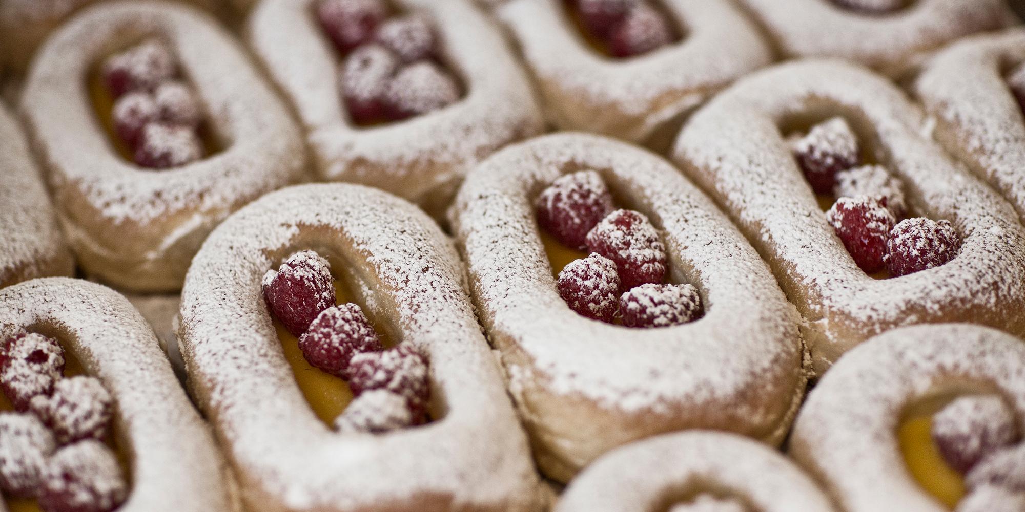Buns on a tray filled with berries and custard