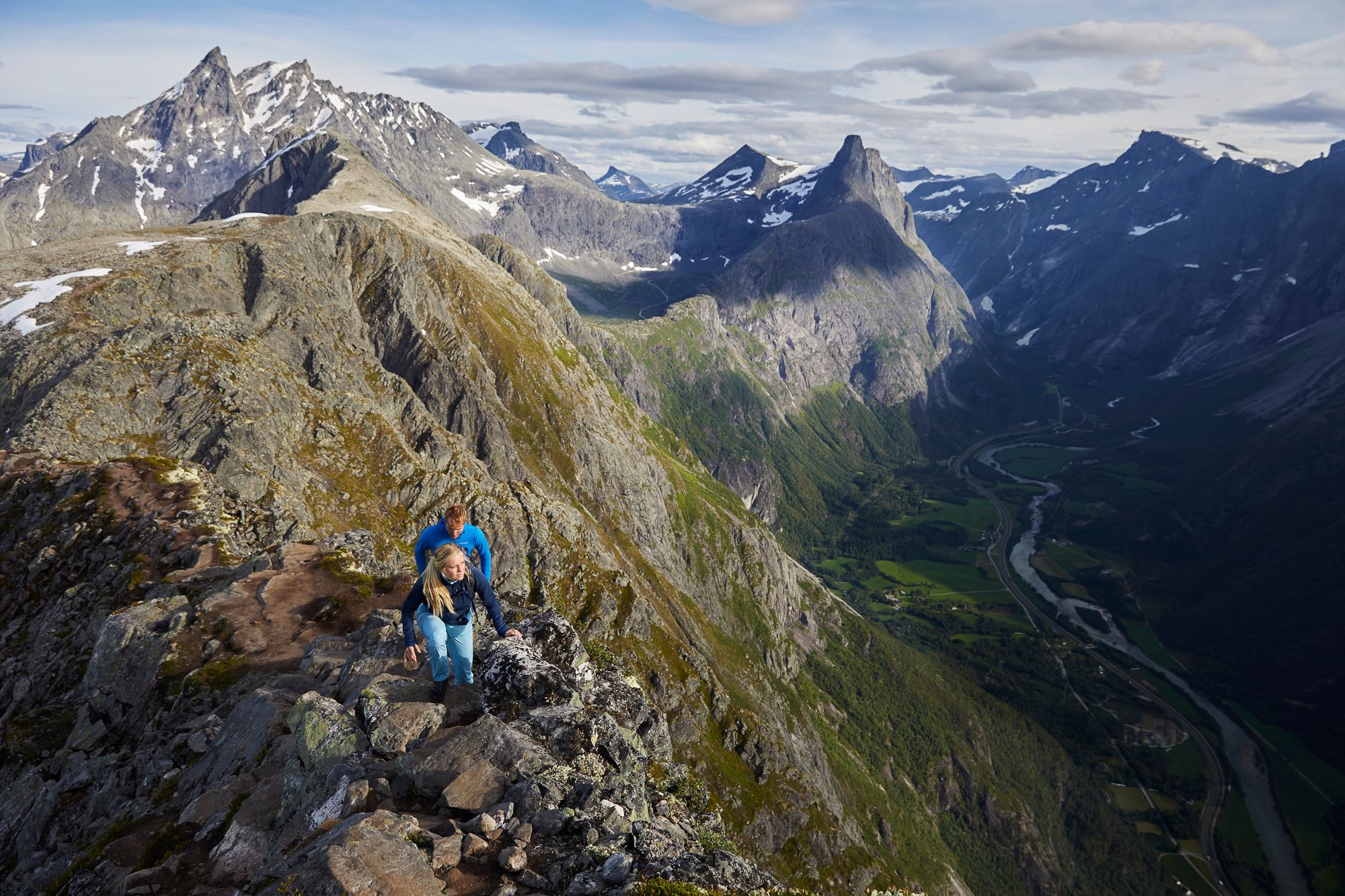 Two people hiking the Romsdalseggen ridge in Åndalsnes, Fjord Norway