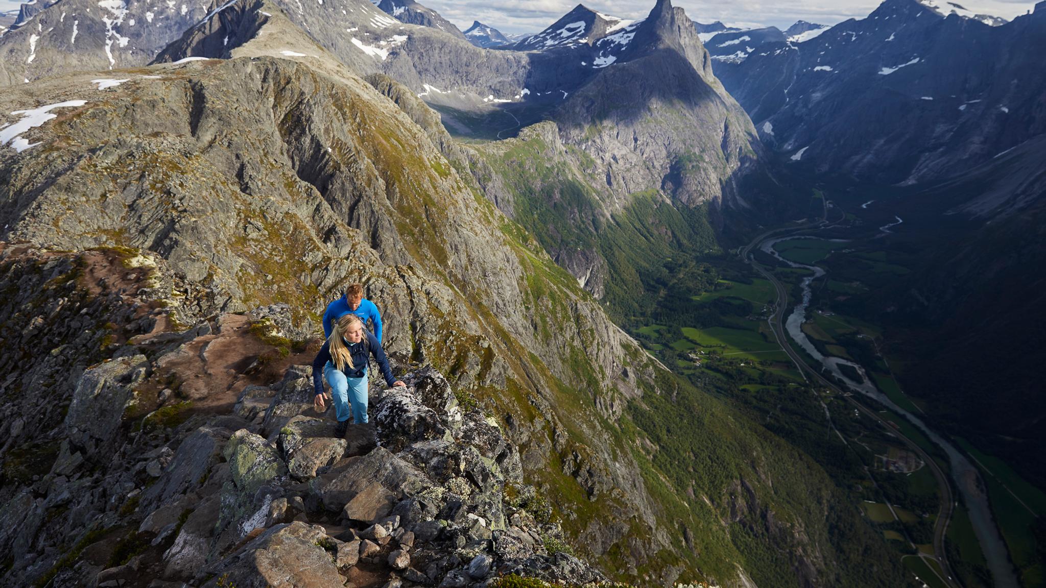 Two people hiking the Romsdalseggen ridge in Åndalsnes, Fjord Norway