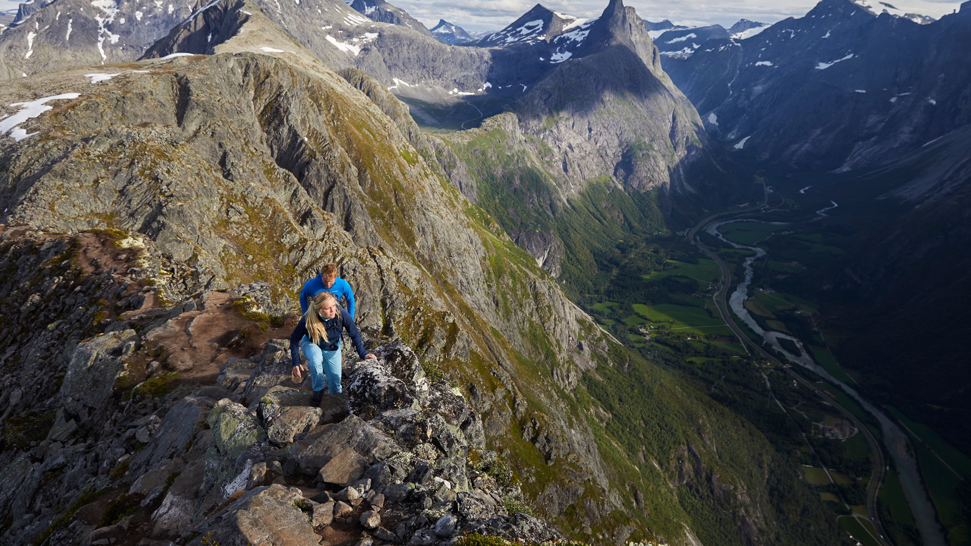 Two people hiking the Romsdalseggen ridge in Åndalsnes, Fjord Norway