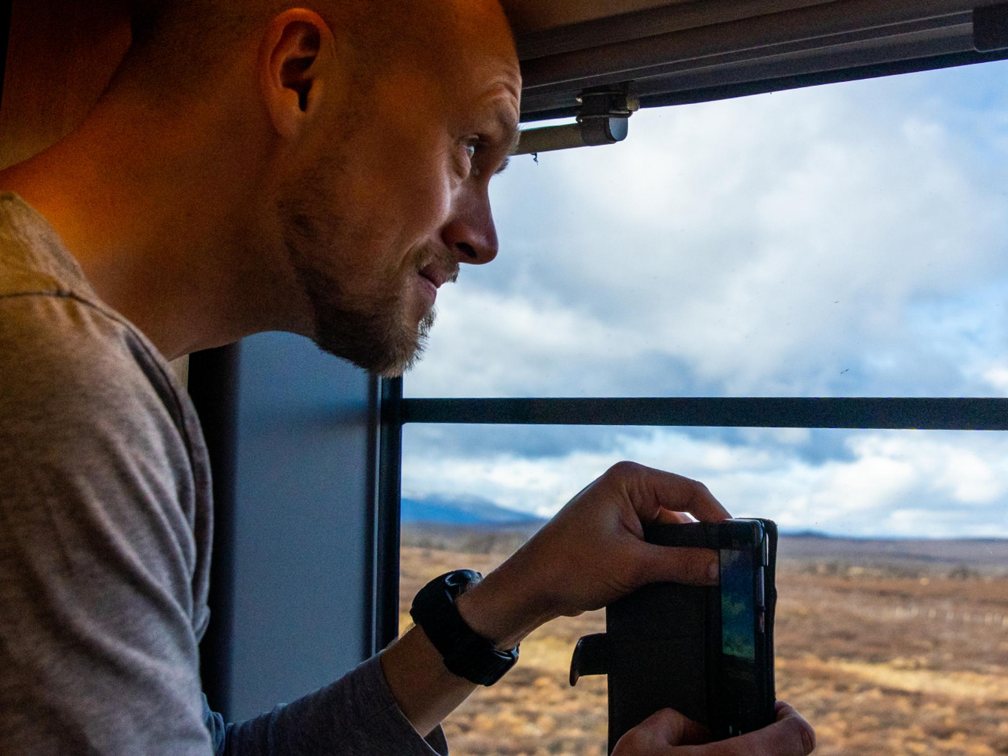 En mann tar bilde på Dovrefjell på Dovrebanen