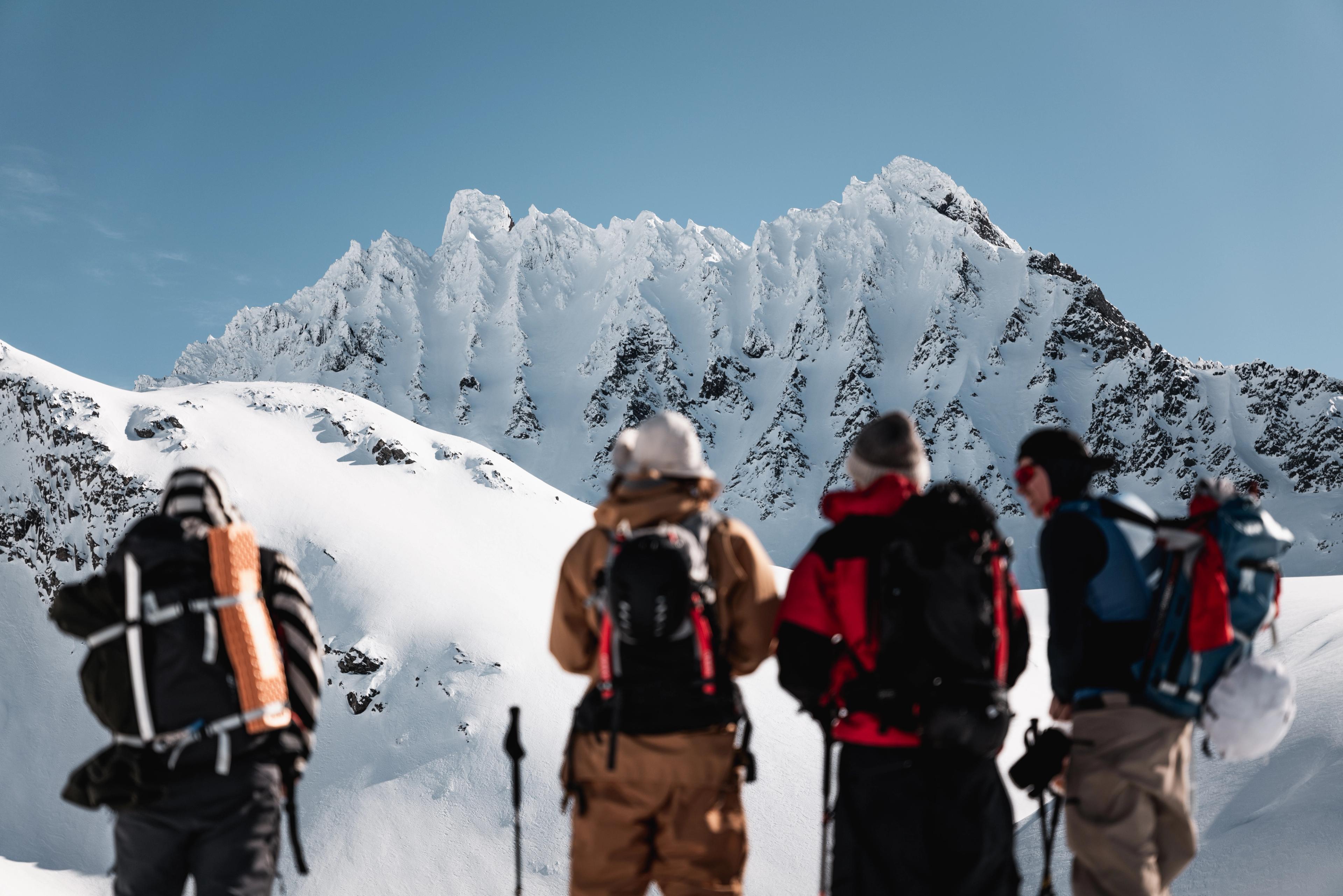 A group of people ski touring to Smørskredtindane in the Sunnmøre alps in Fjord Norway
