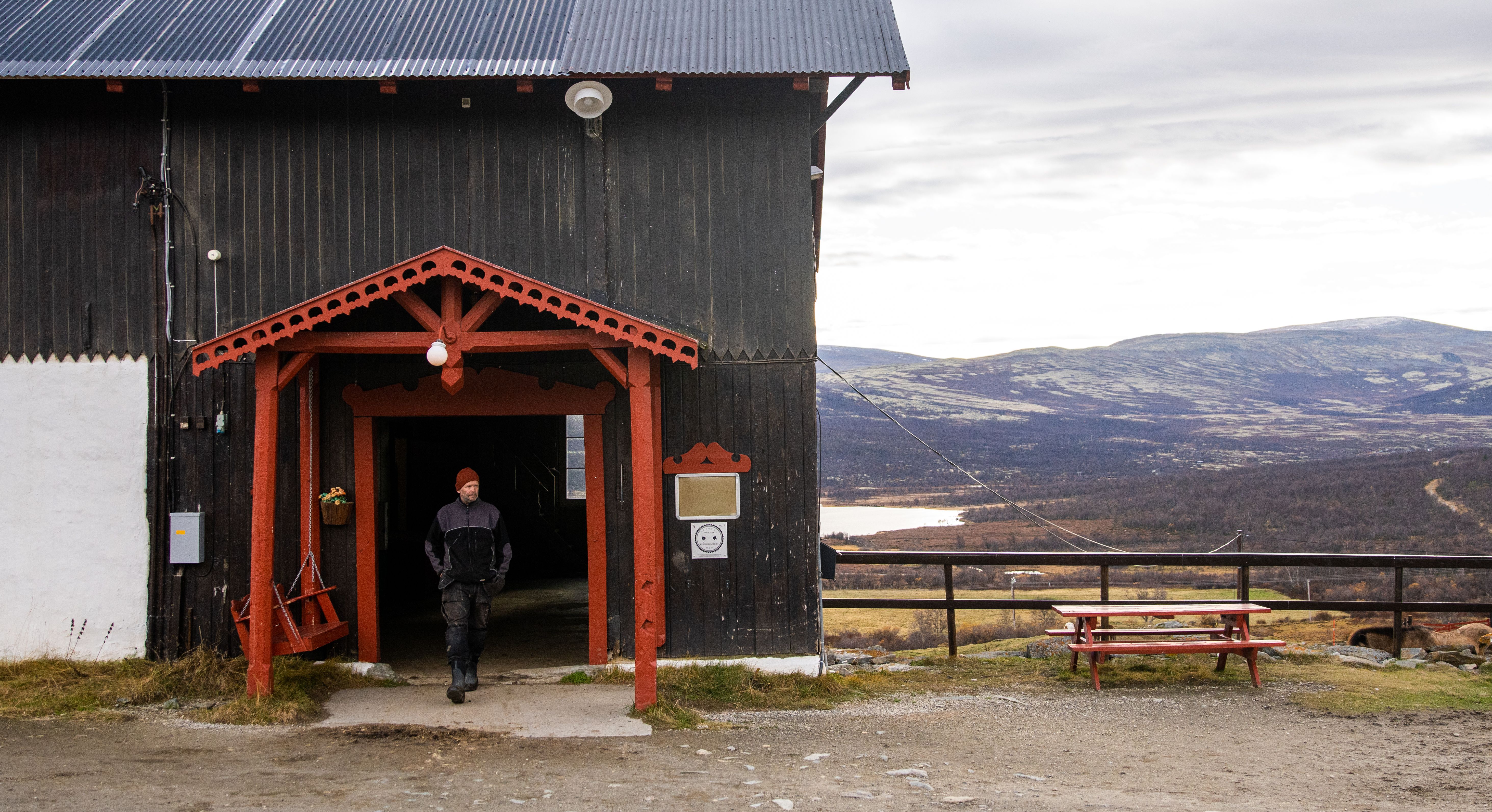 The stable at Hjerkinn Fjellstue, mountain lodge, with mountains in the background.